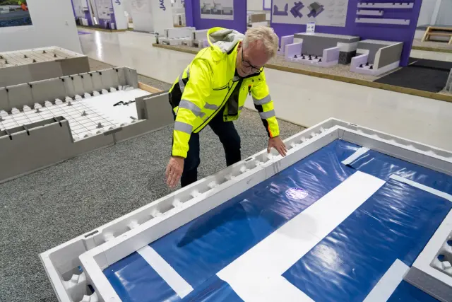 Mann i gul jakke (utviklingssjef Eivind Olsen i Bewi) viser frem Jackon Ringmur RA