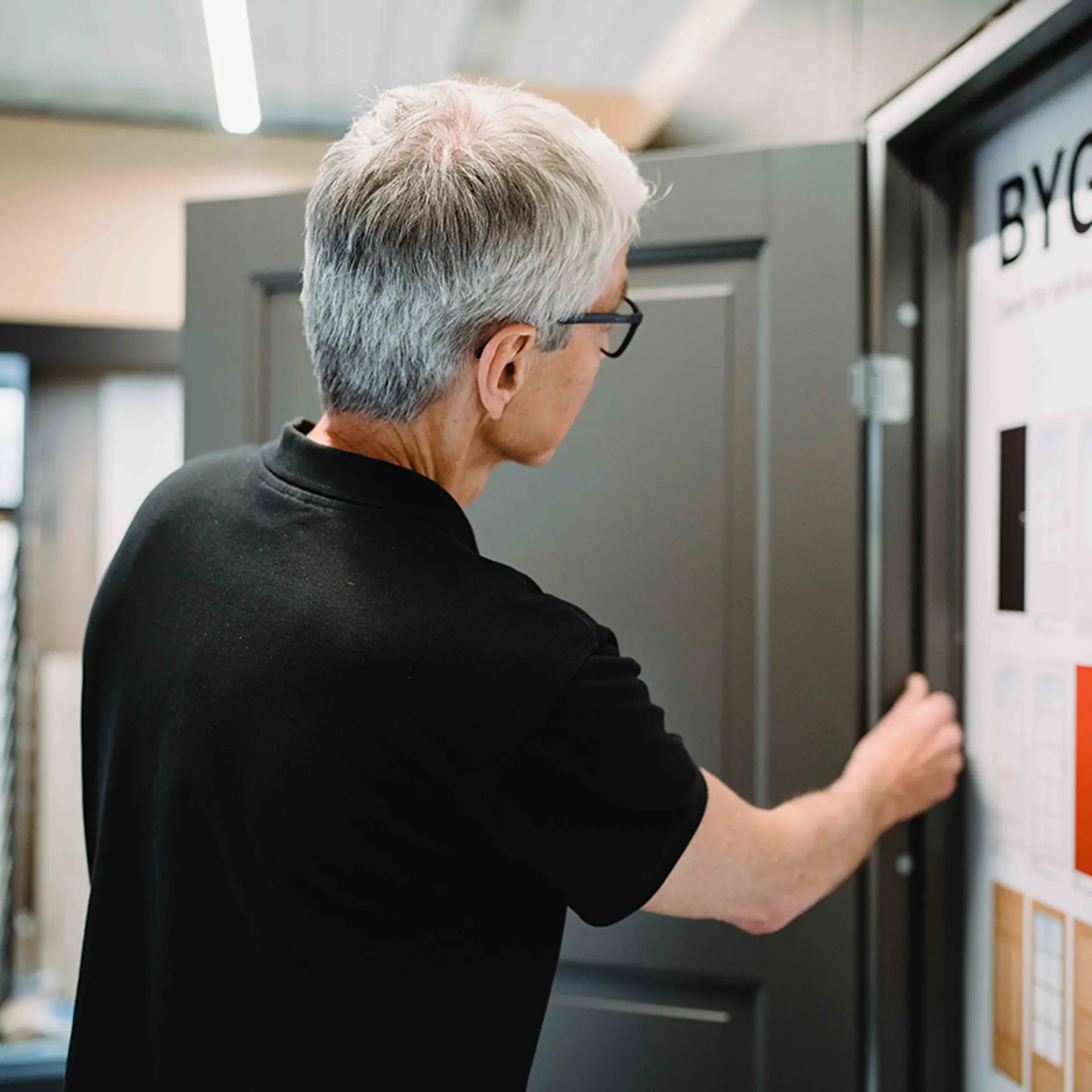 Ansatt viser frem dør i byggevarehus