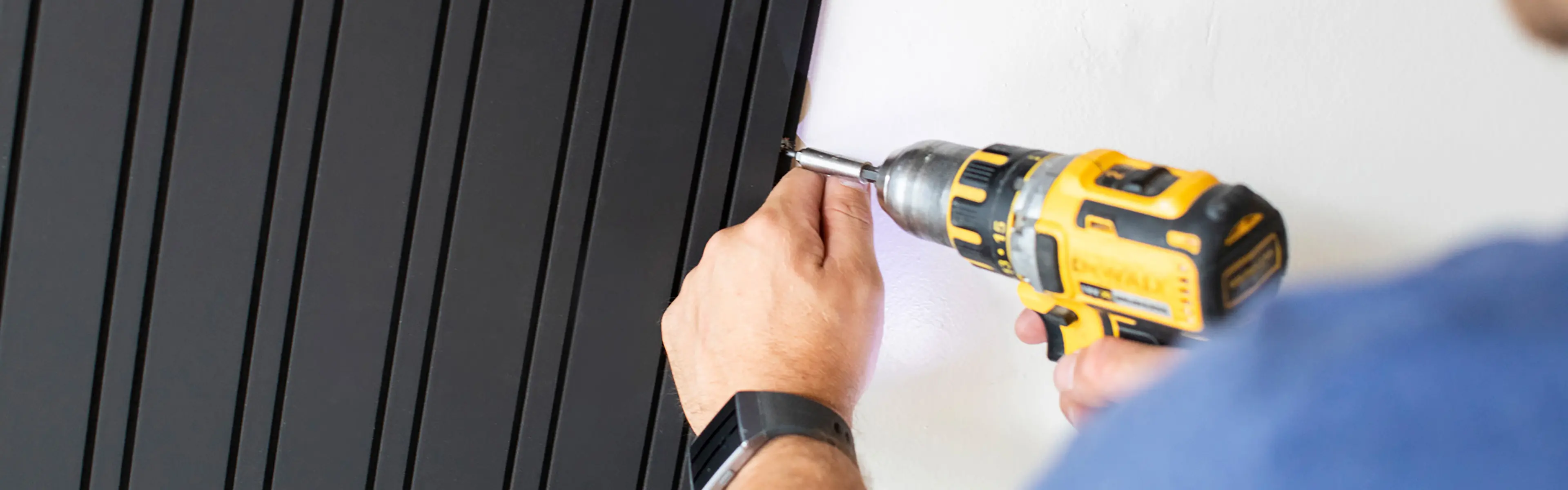 Mann monterer spilepanel på vegg