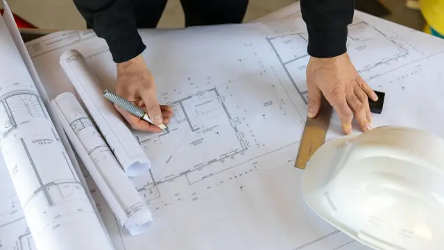 Person som ser på plantegning etter det nye bygningsenergidirektivet.