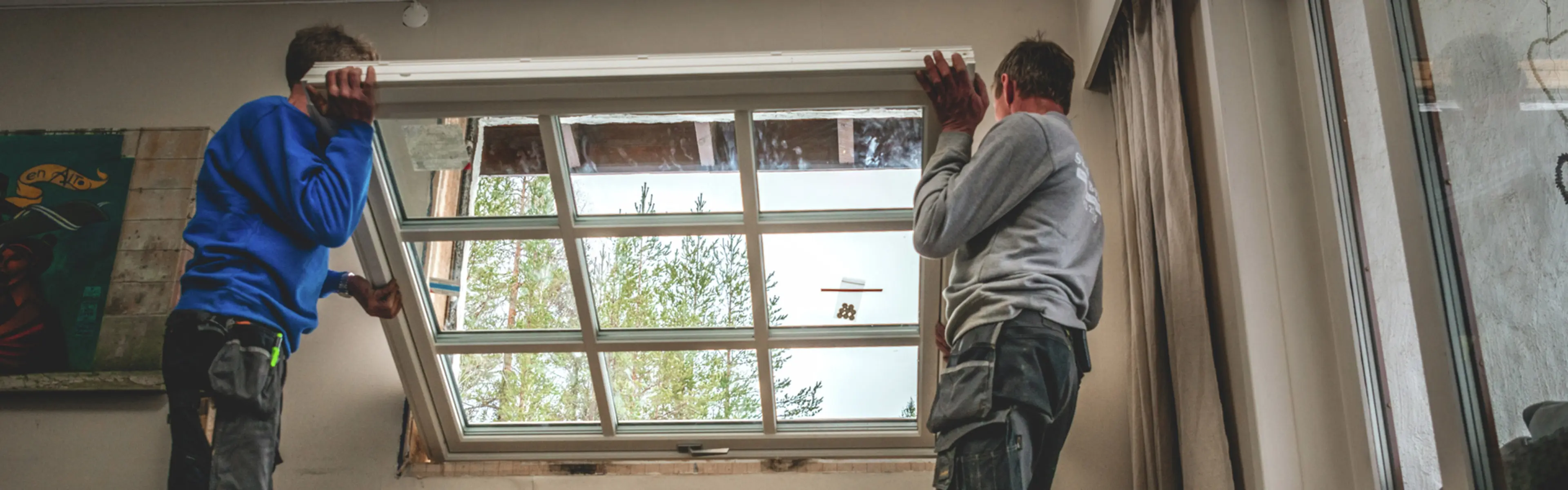 To håndverkere som holder på å bytte vinduer.