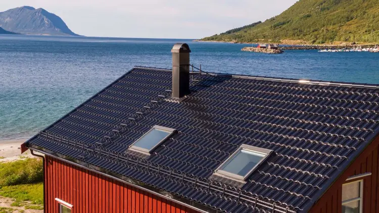 Rødt hus ved sjøen med Isola Powertekk tak.