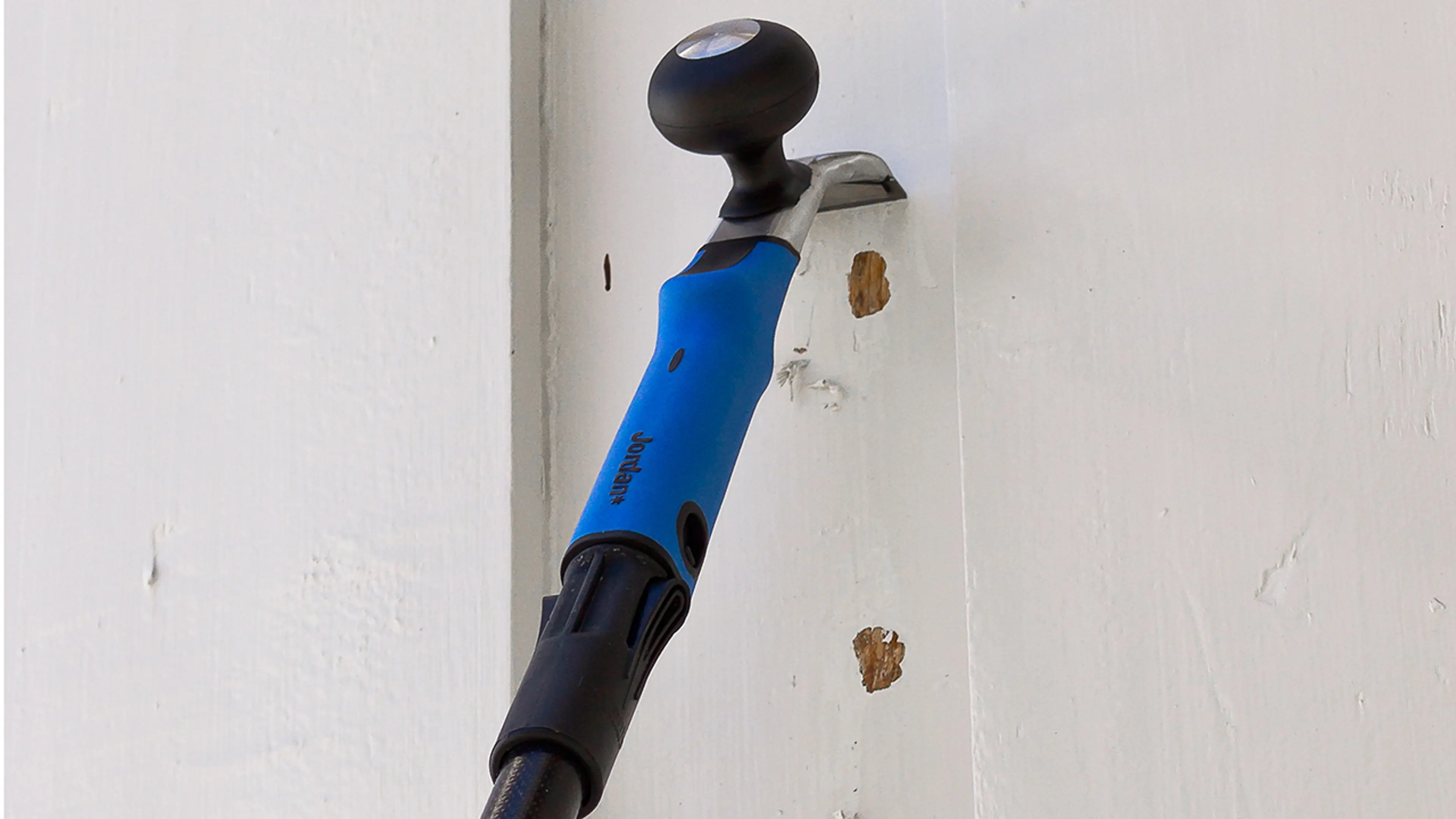 Malingsskrape som skraper maling av husvegg før maling.