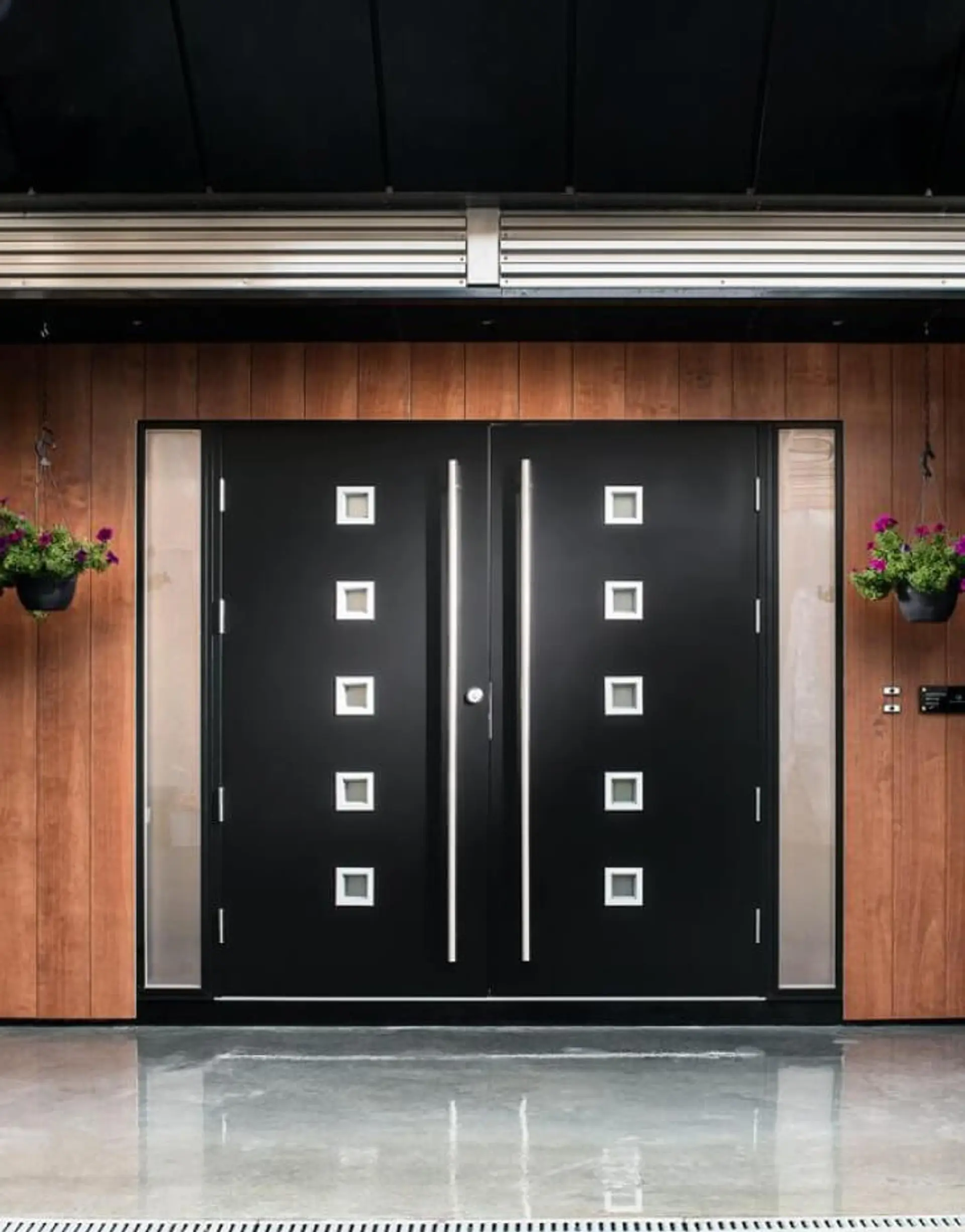 Svart ytterdør med sidefelt og glass.