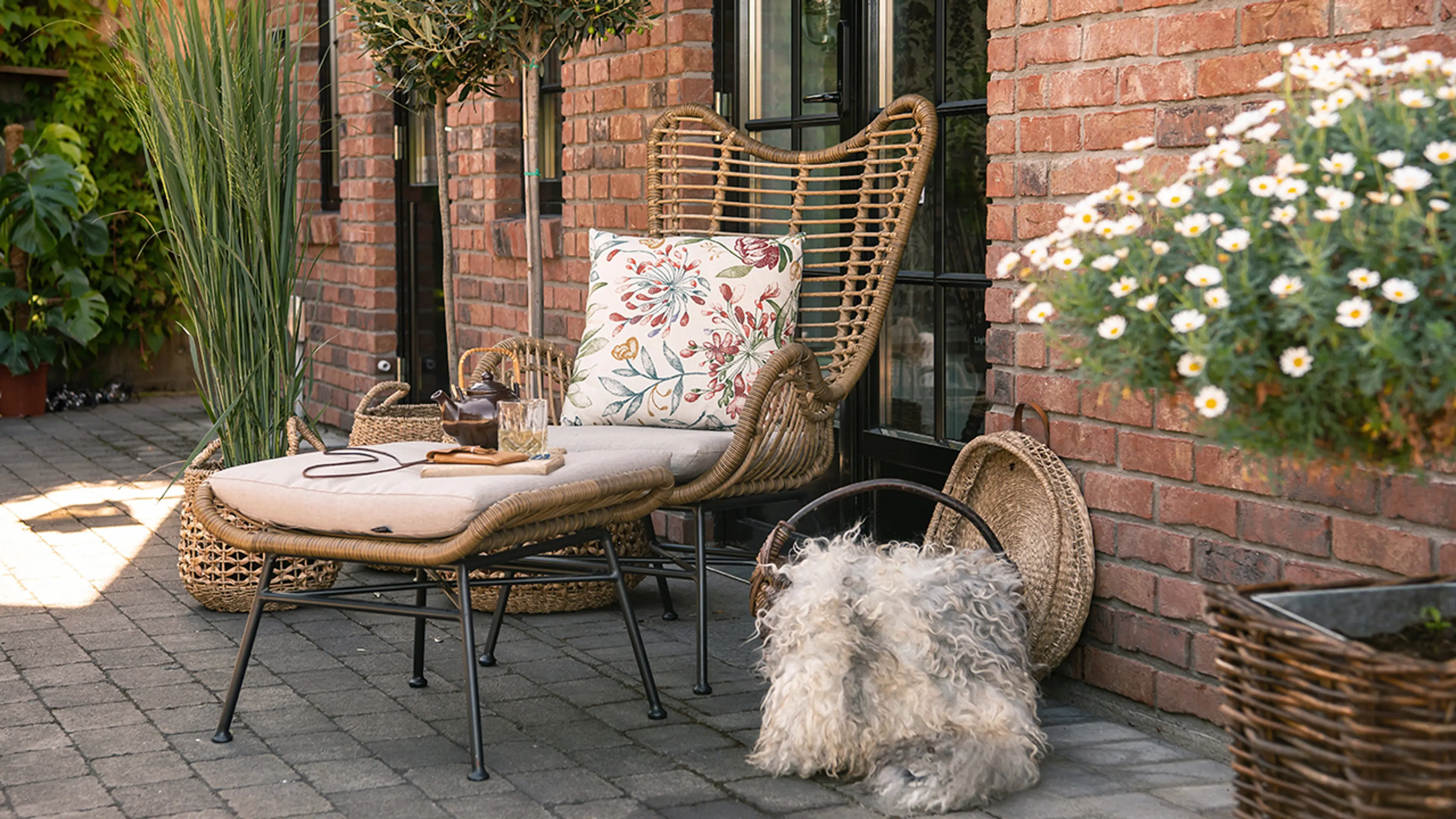 Aaltvedt belegningsstein utenfor murhus med sittegruppe.