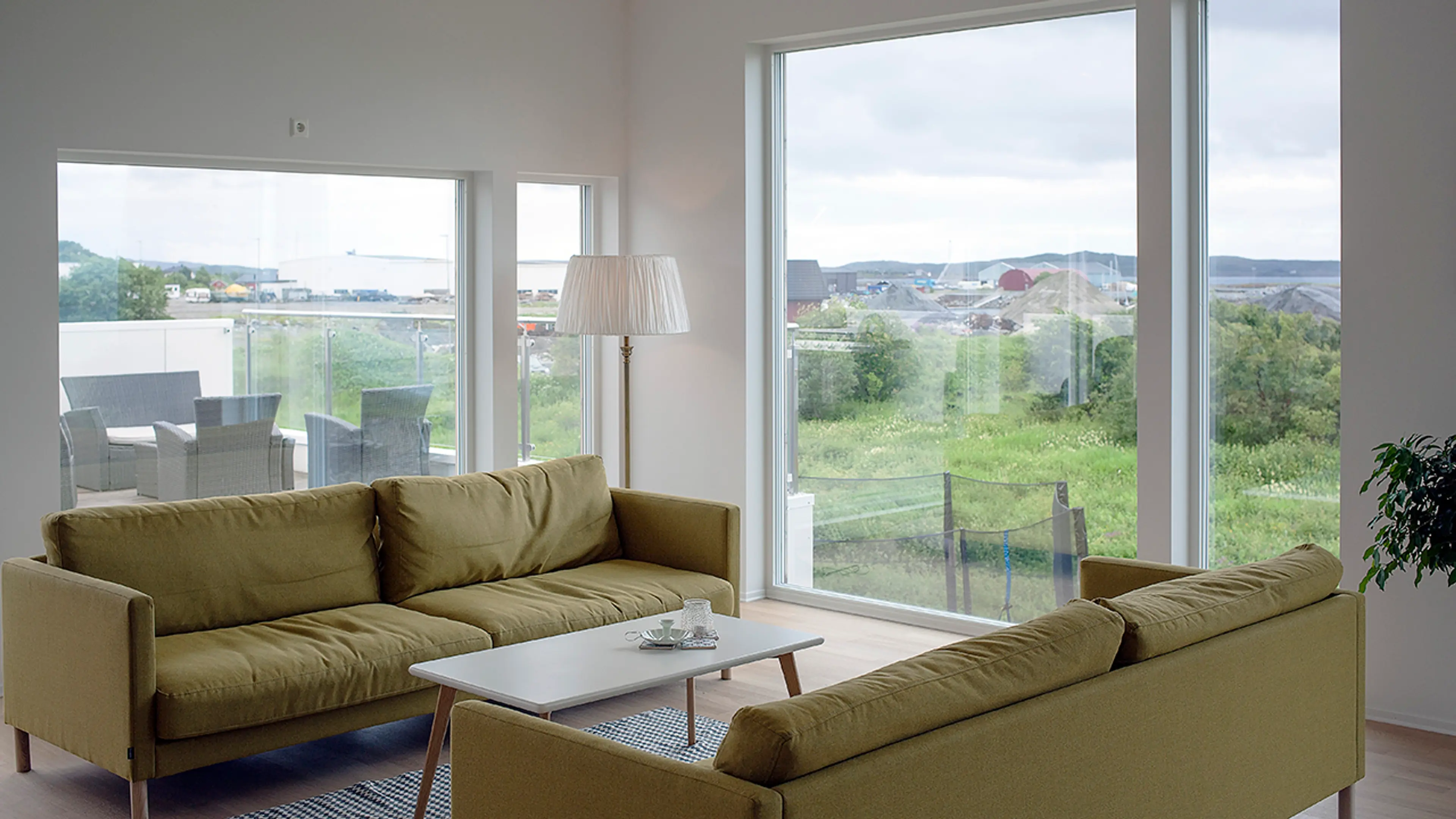 Stue med to sofaer i moderne hus med store vindusflater.