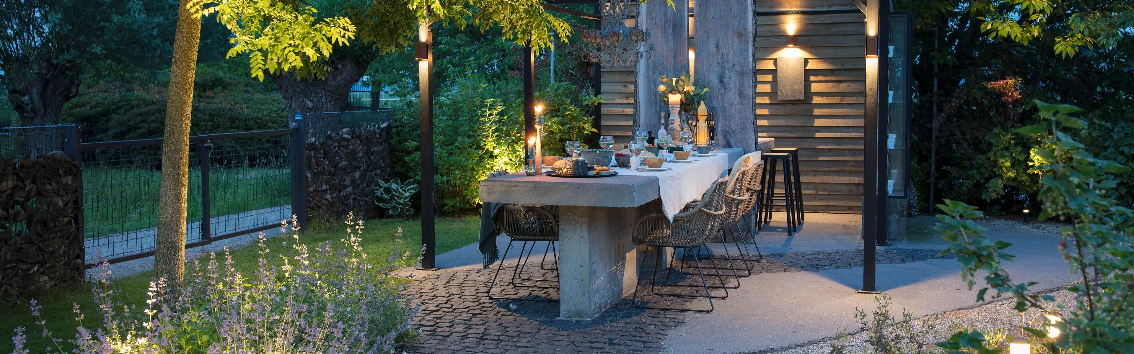 Sitteplass i hage som er opplyst med utendørsbelysning.