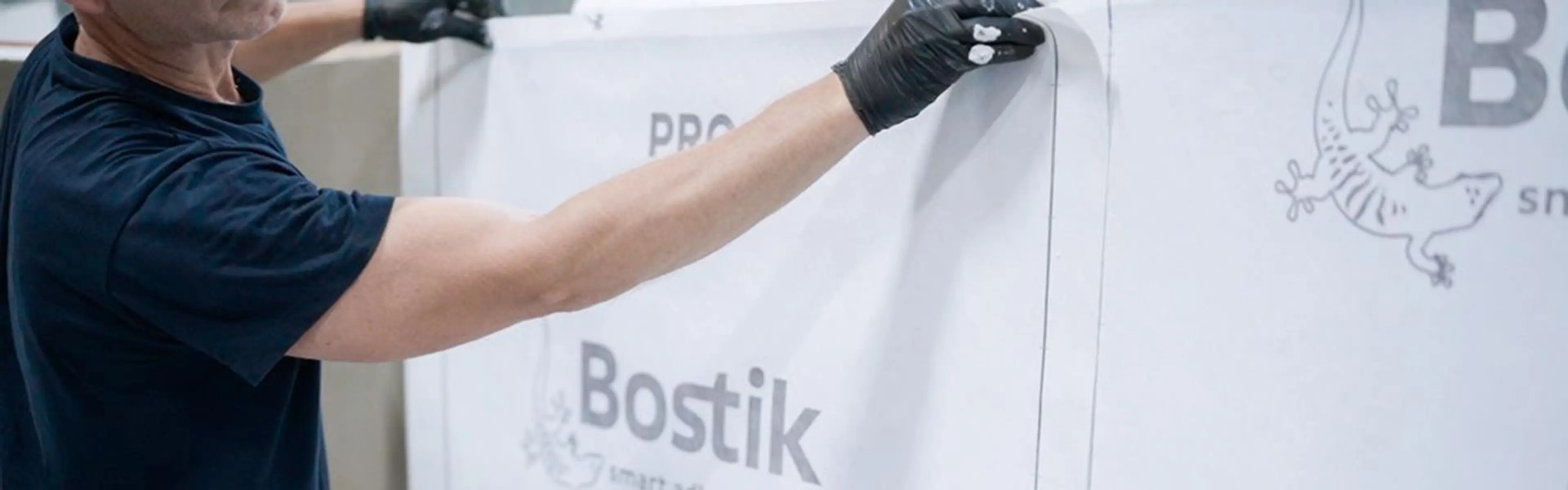 Bostik PRO vanntettingssystem som festes til vegg av mann med hansker.