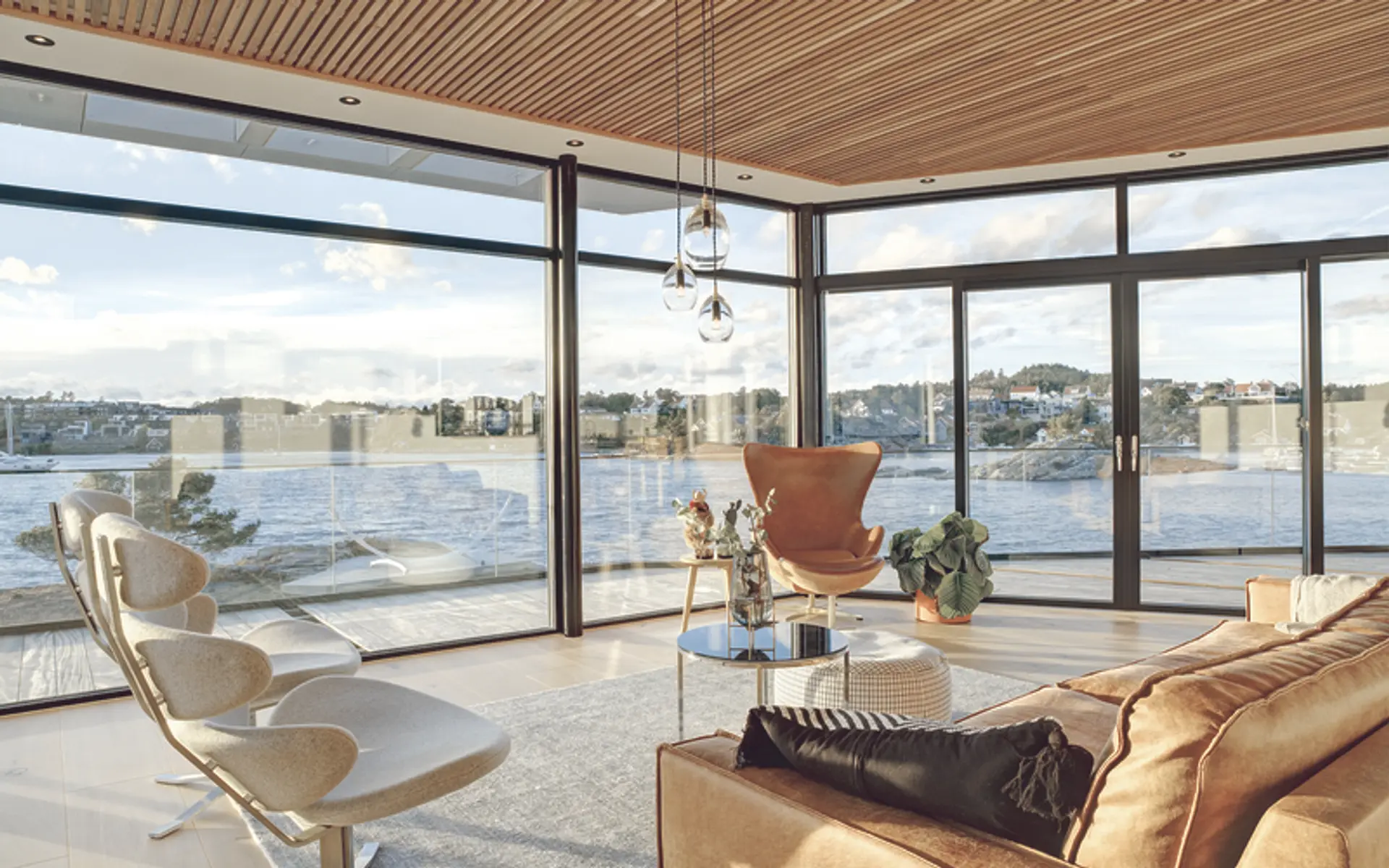 moderne stue i leilighetskompleks ved sjøen, med vinduer på to vegger