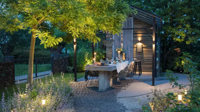 Sitteplass som er opplyst med hagebelysning.