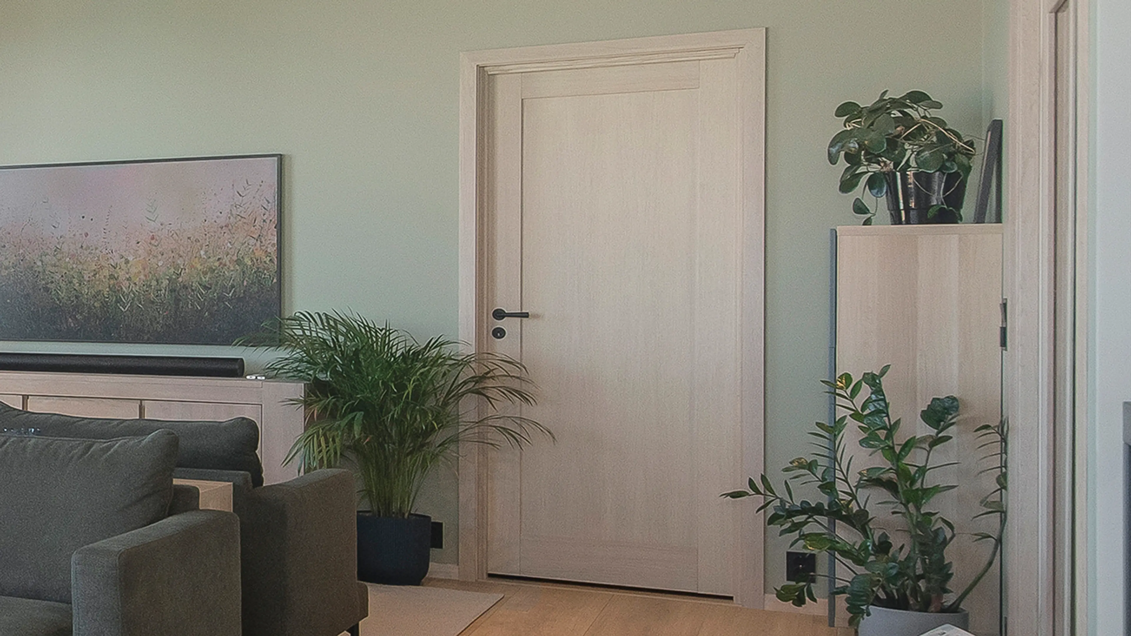 Stue med eik innerdør mes sort håndtak og vrider.