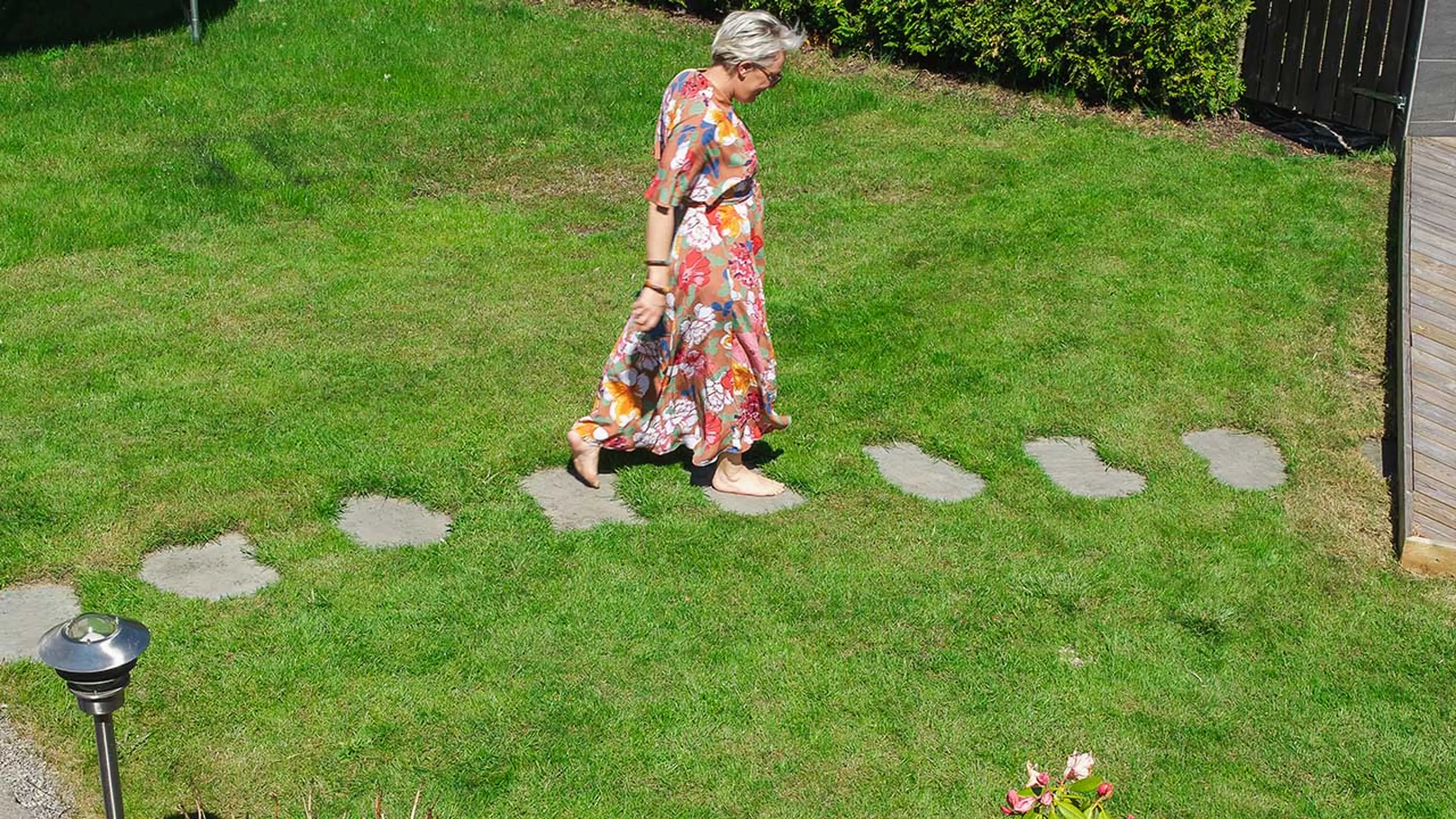 Kvinne som går på heller på plen.