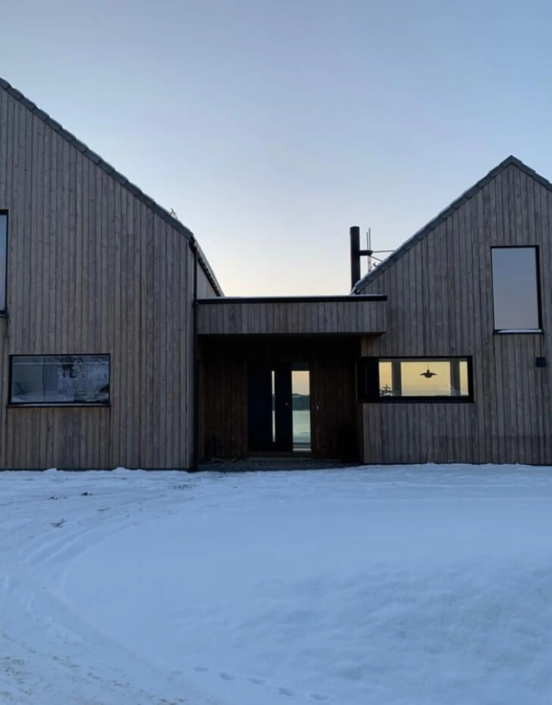 Svart ytterdør med glass på moderne hus.