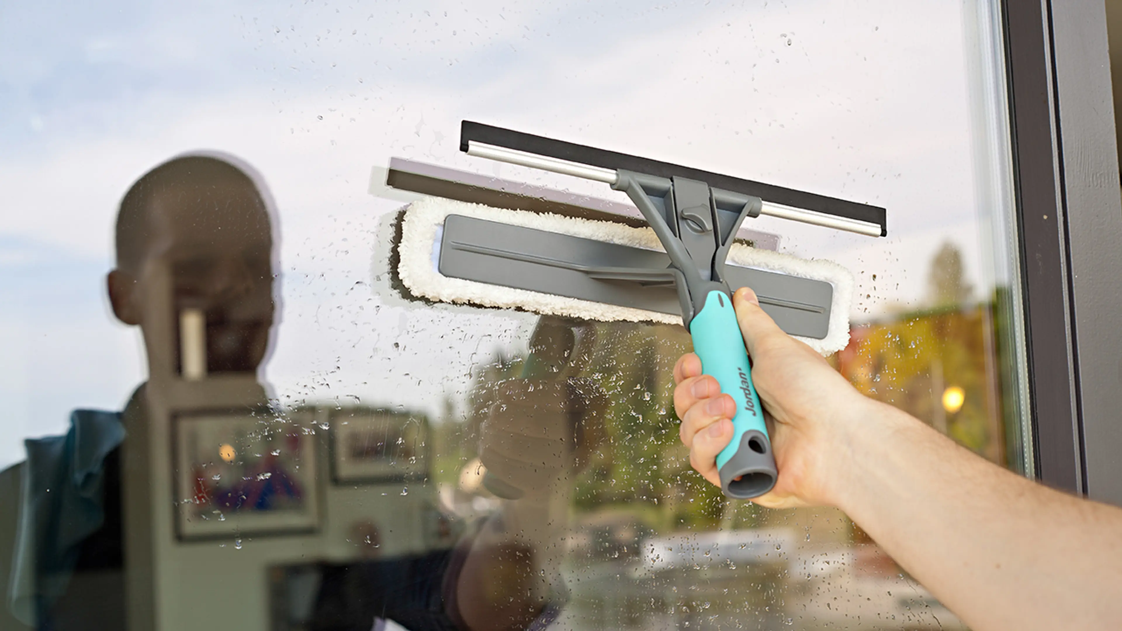 Person som demonstrer hvordan vaske vinduer ute med vindussett.