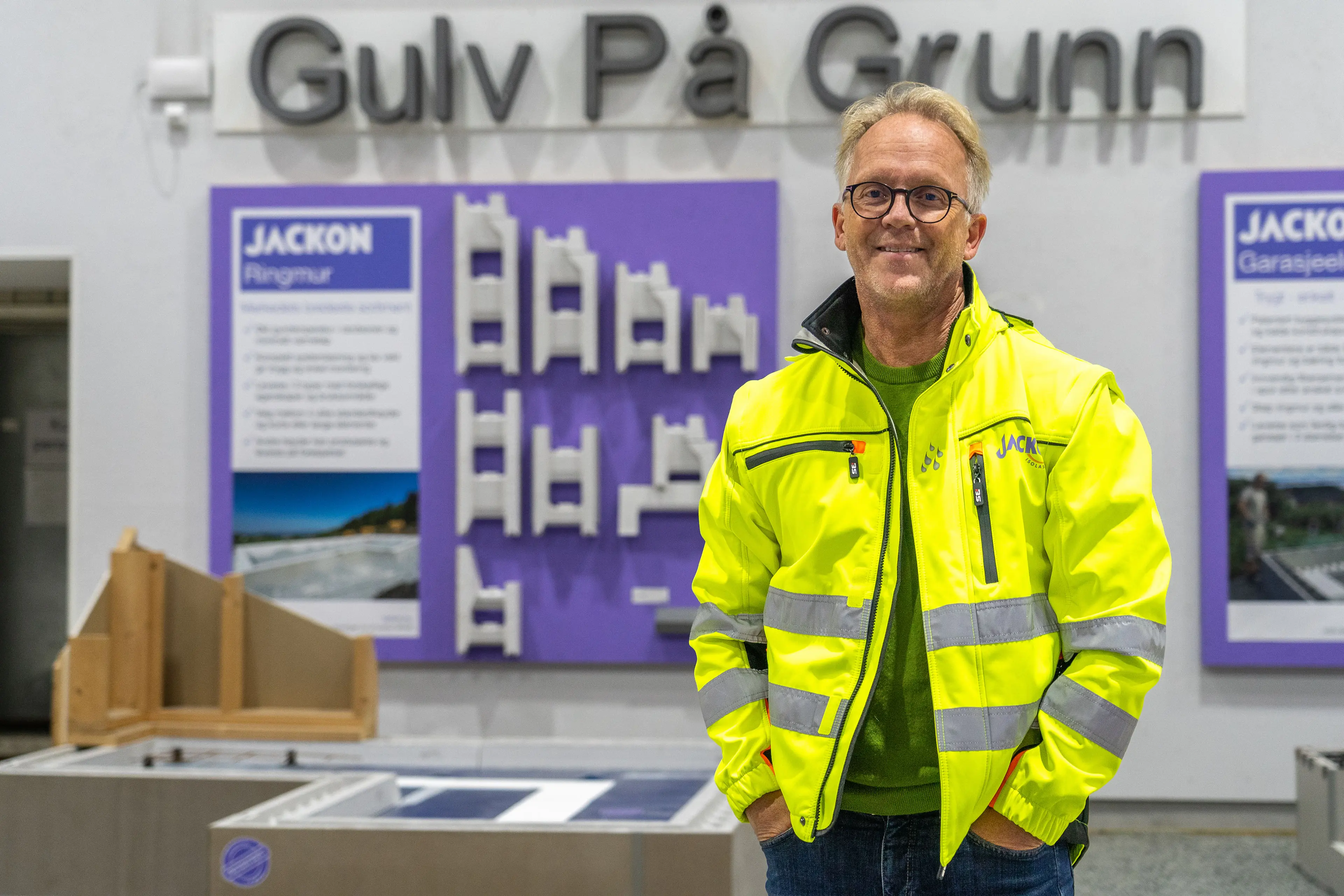 Mann i gul jakke (utviklingssjef Eivind Olsen i Bewi) ser i kamera inne på en fabrikk