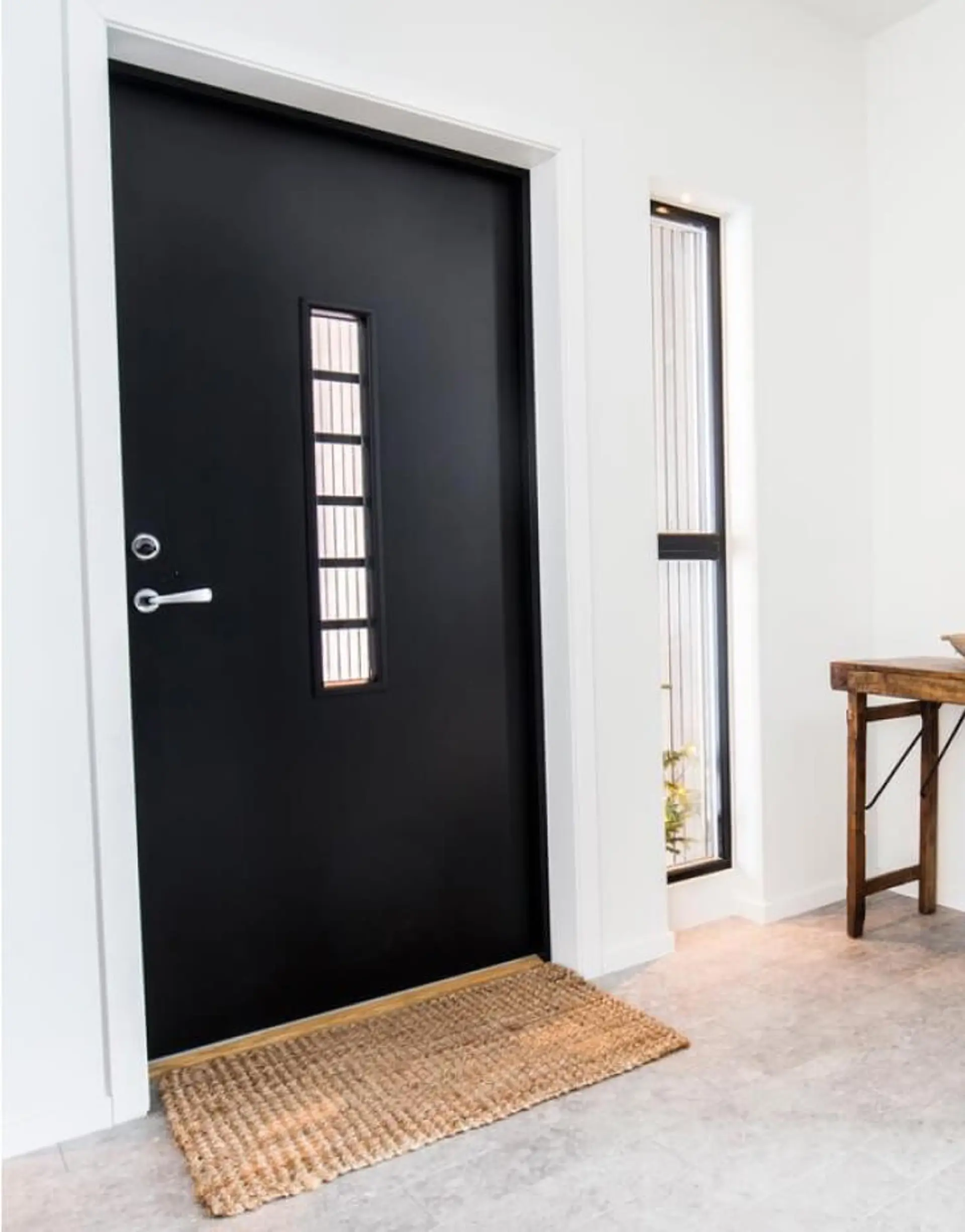 Svart ytterdør med glassfelt.