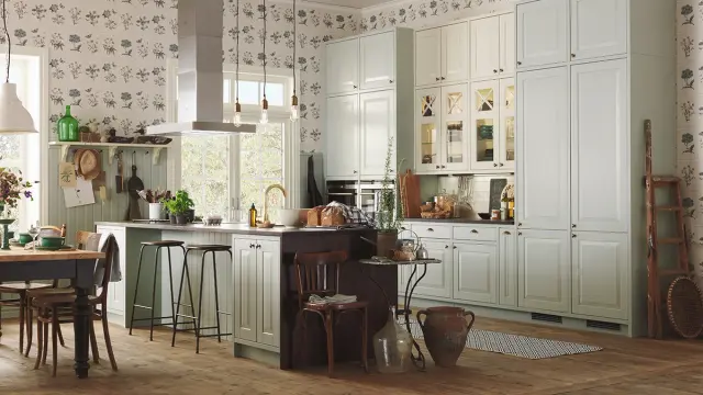 Landlig kjøkken med kjøkkenøy og vitrinefronter på overskap.