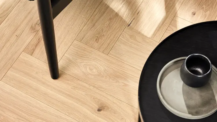 Nærbilde av ny fiskebensparkett etter vannskade gulv.