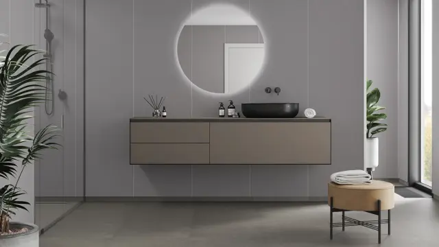 Bad med grå veggplater og brun baderomsinnredning.