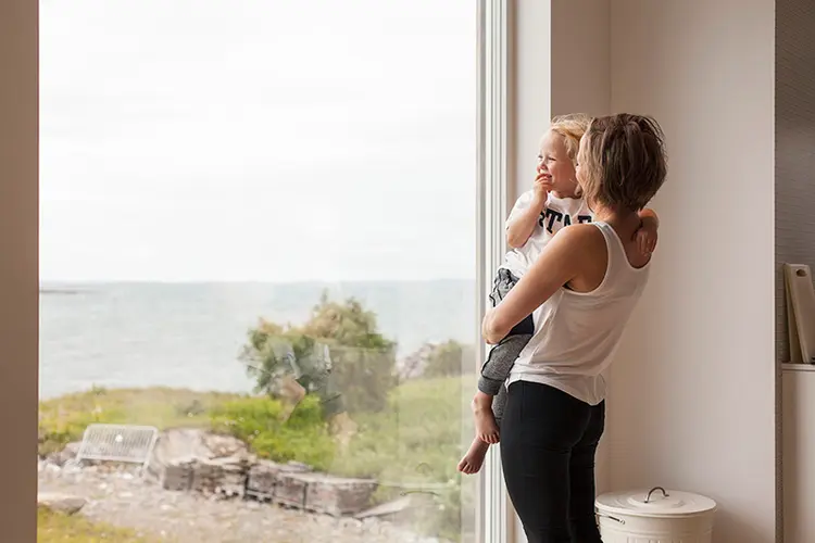 kvinne og barn ser ut av et stort vindu