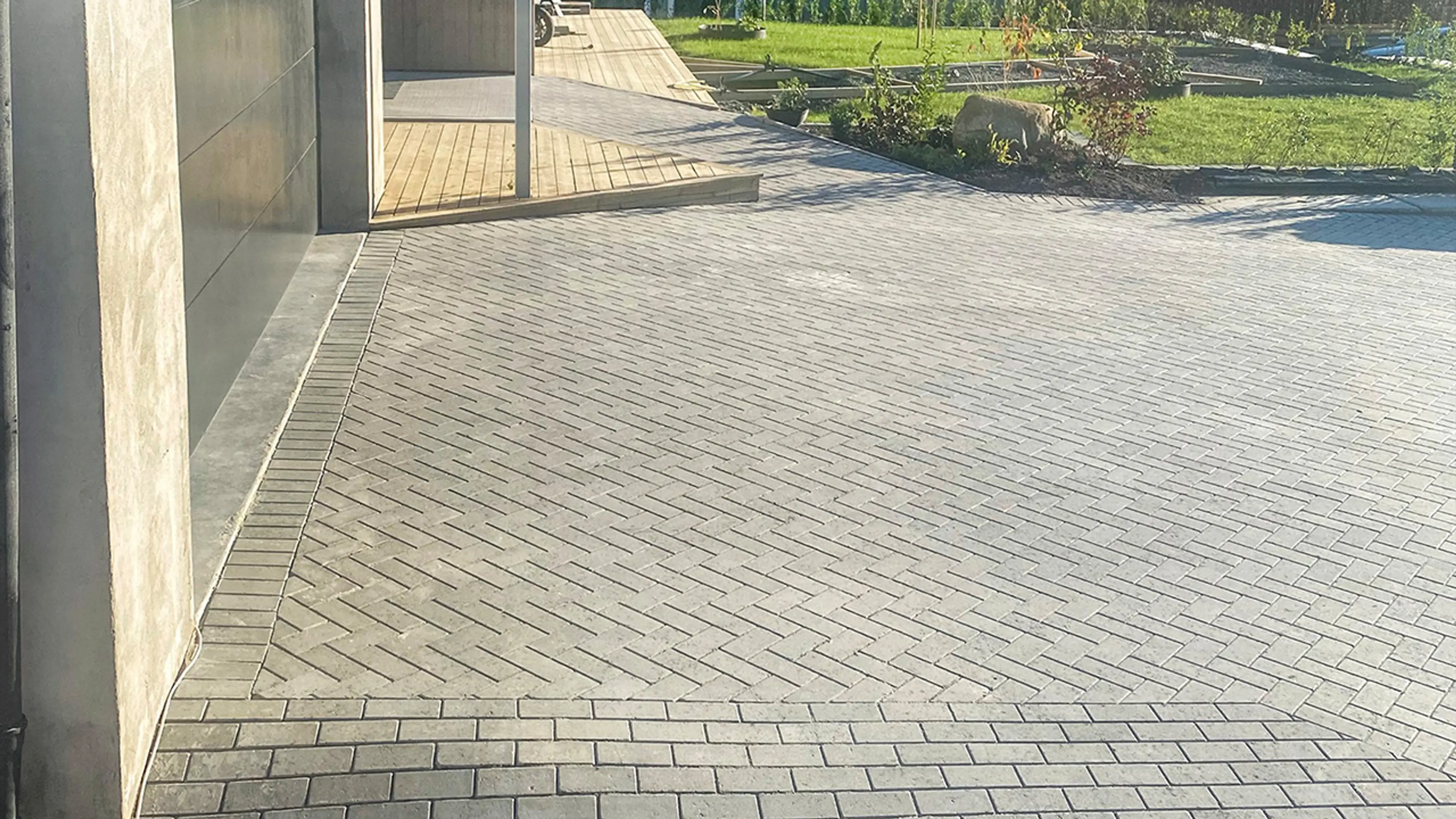 Gårdsplass med grå belegningsstein lagt i mønster.