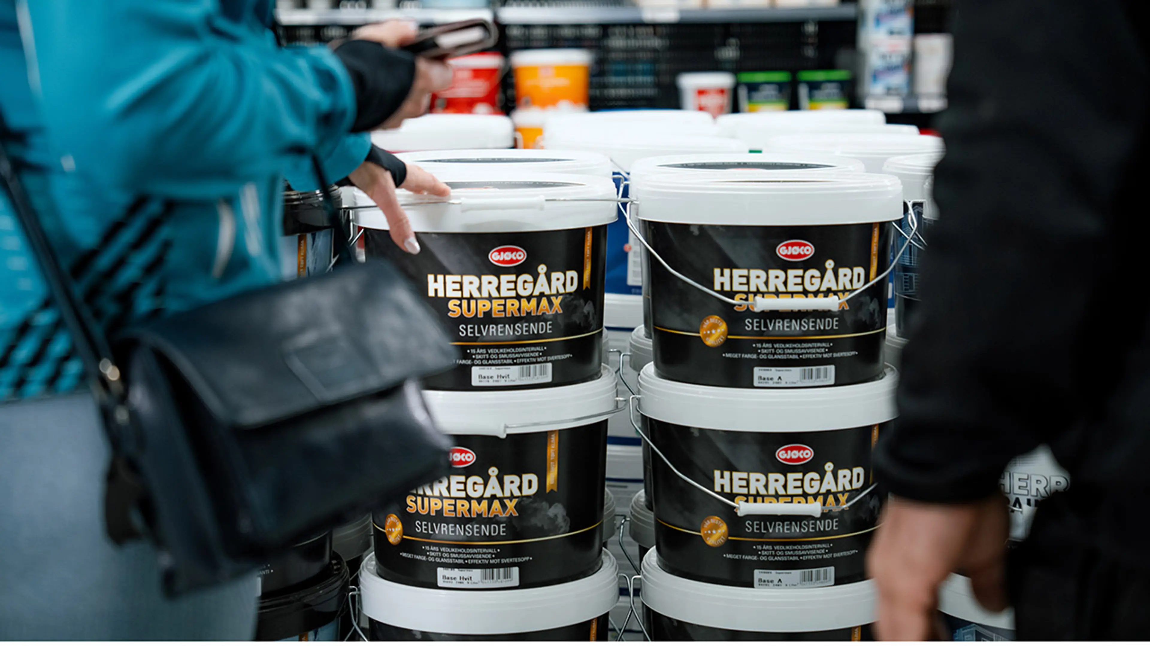 Malingsspann fra Gjøco i byggevarehus og kunder som ser på.