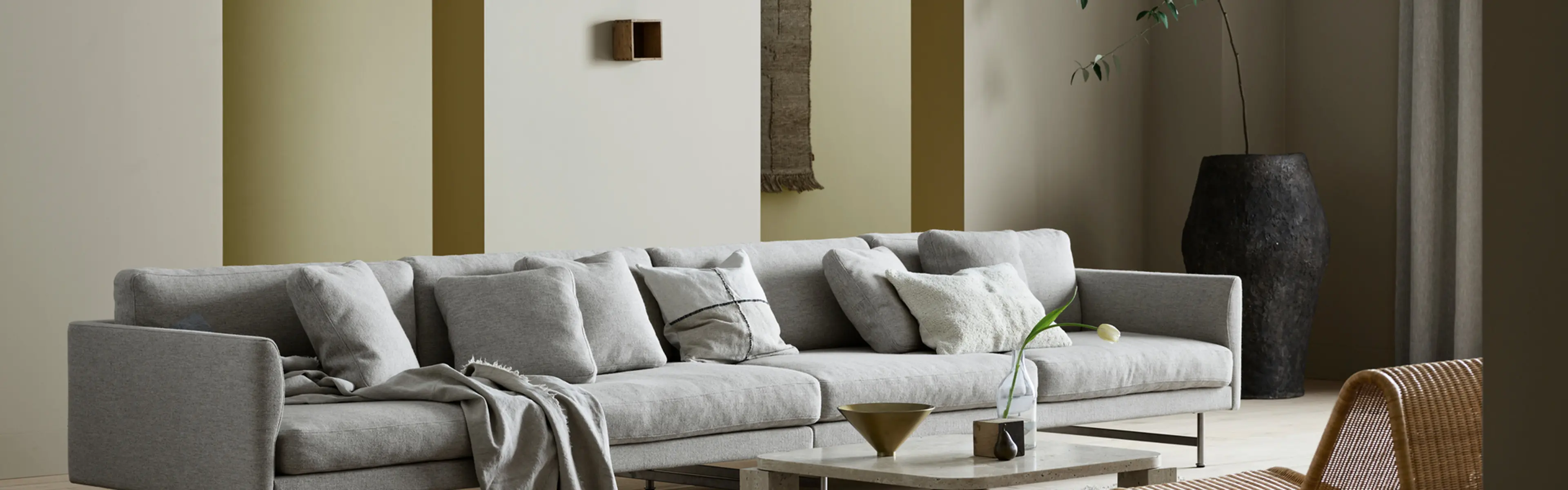 Stue med stor sofa og Jotuns nye trendfarger 12290 Antwerp Beige, 12075 Soothing Beige, 8583 Earthy Yellow og 0288 Mexico.