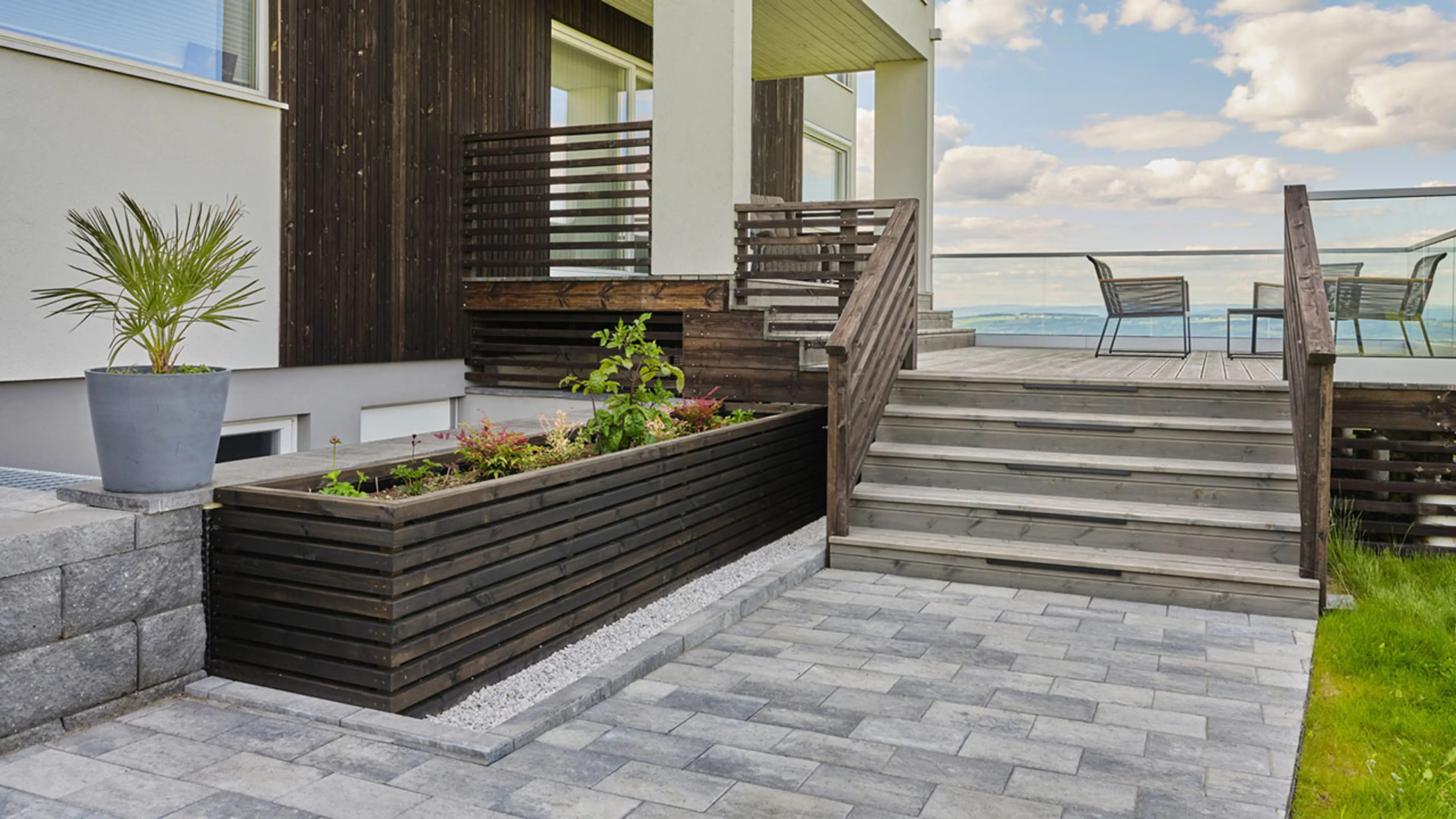 Hage og hus med rekkverk til trapp til veranda.