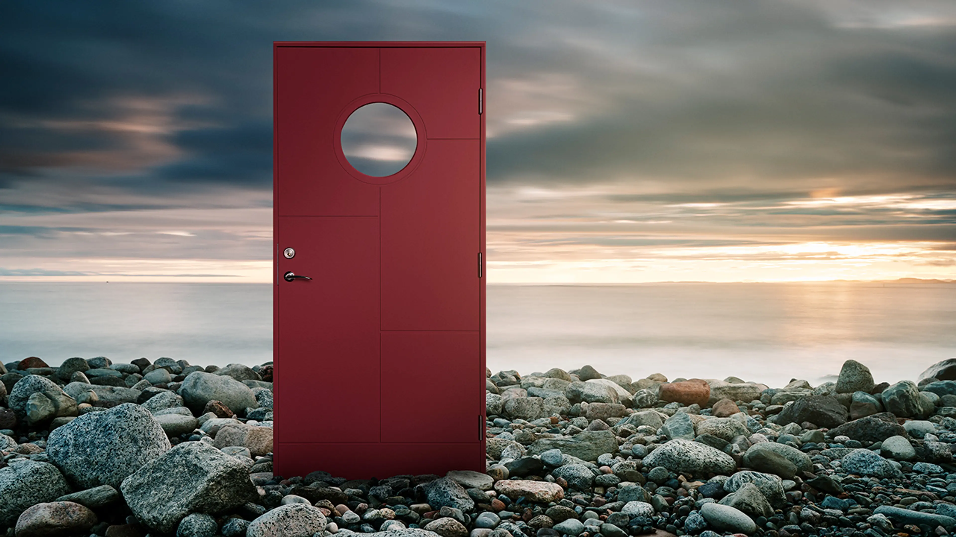Rød hyttedør ved sjøen.