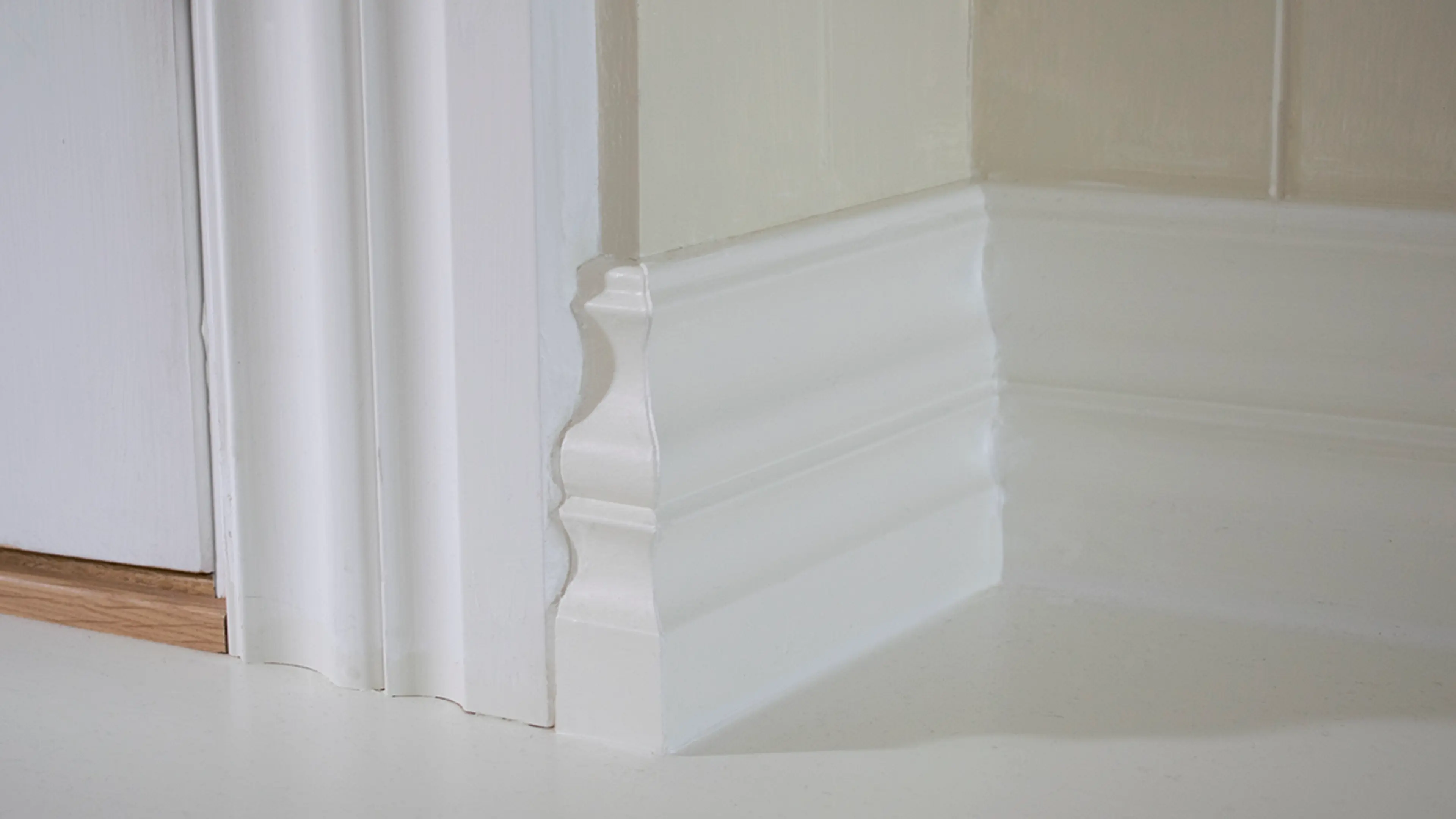 Brede lister med profil i hvitt til hvitt gulv.