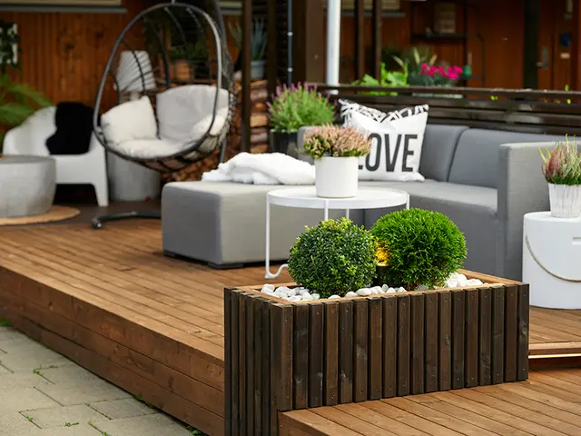 inspirerende terrasse med blomsterbed og sofa