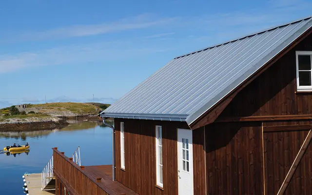 Hus ved sjøen med takplater.