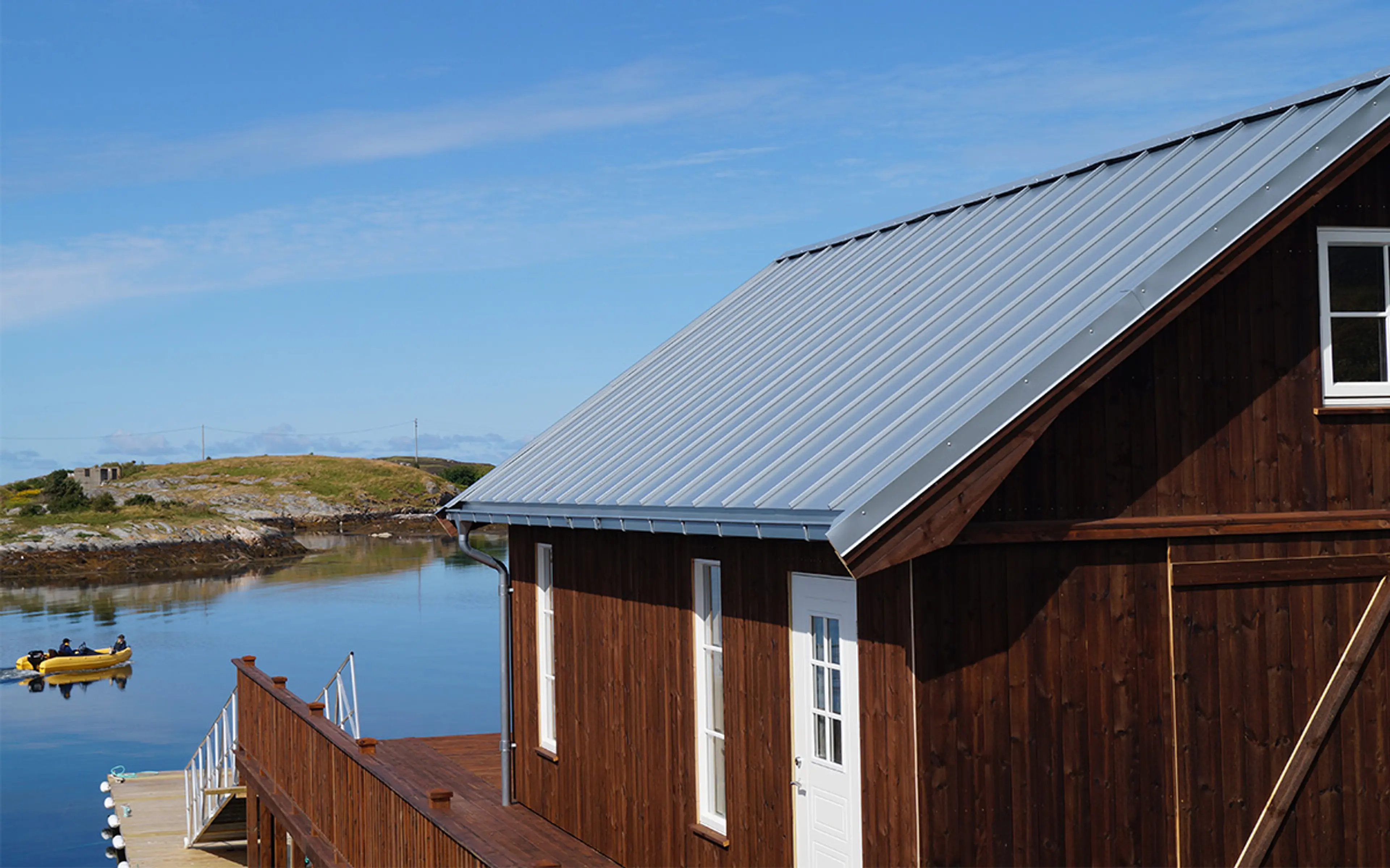 hytte ved sjøen med rektangulære takrenner og stålplater på taket