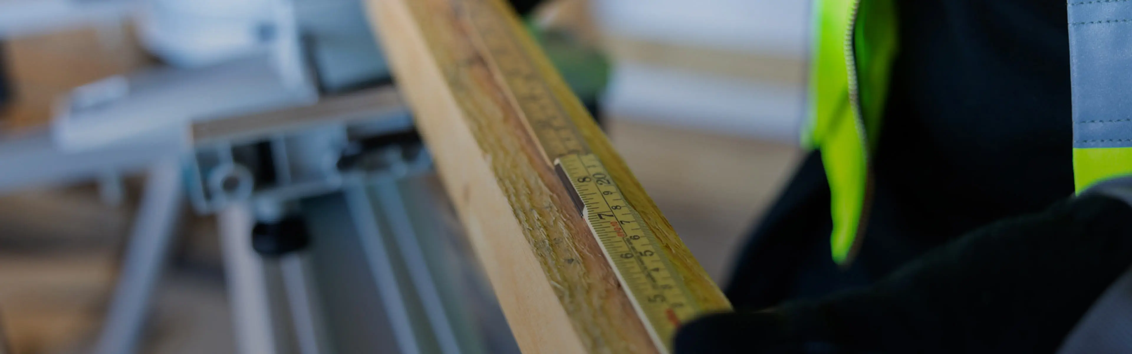 Person som måler en planke med tommestokk.