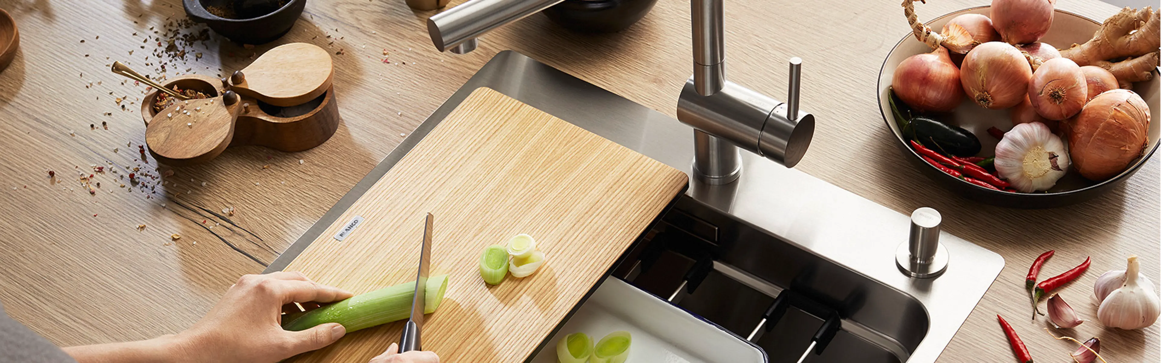 Person som kutter grønnsaker i kjøkkenvask med mange muligheter.