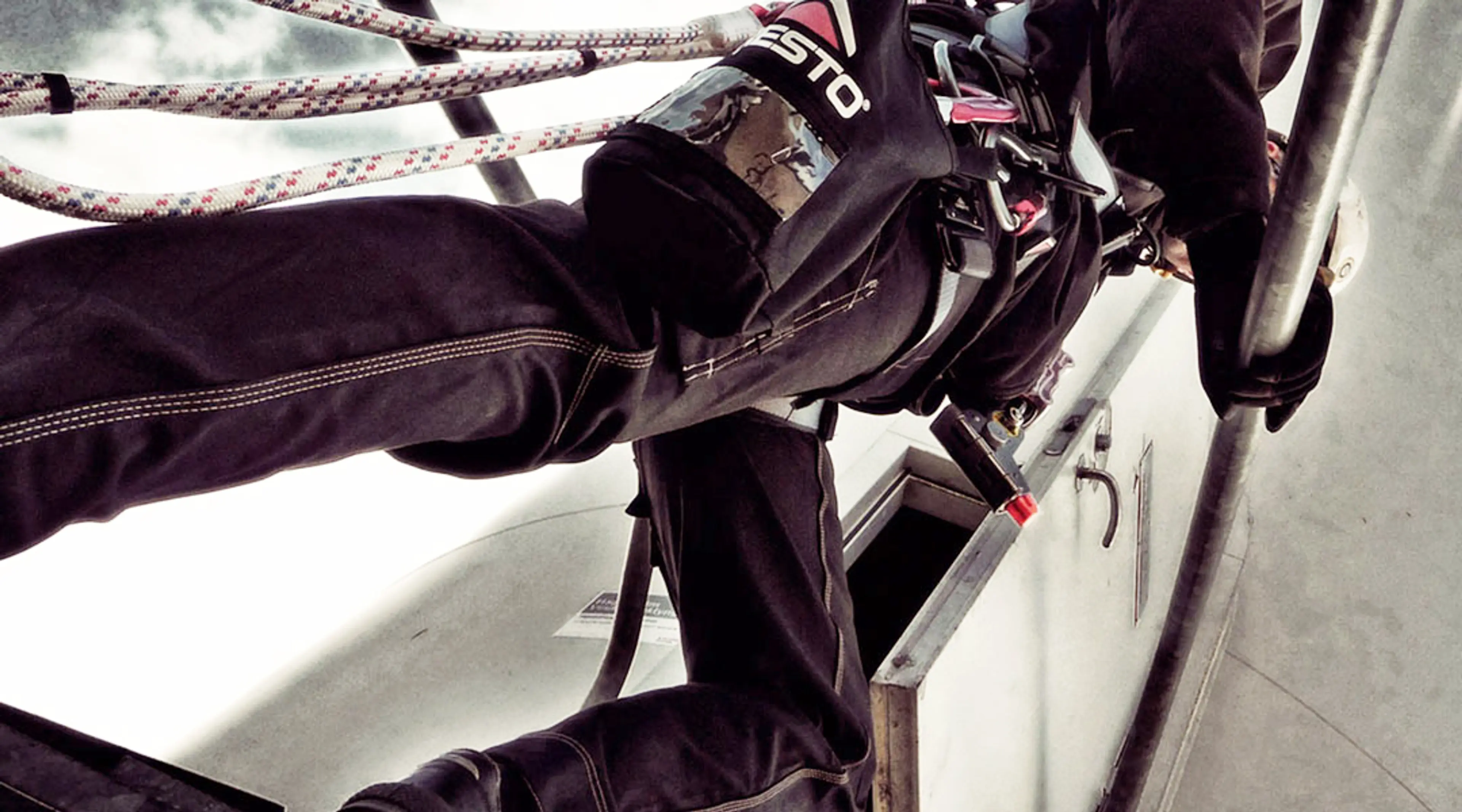 Mann som er fallsikret i stillas på byggeplass.