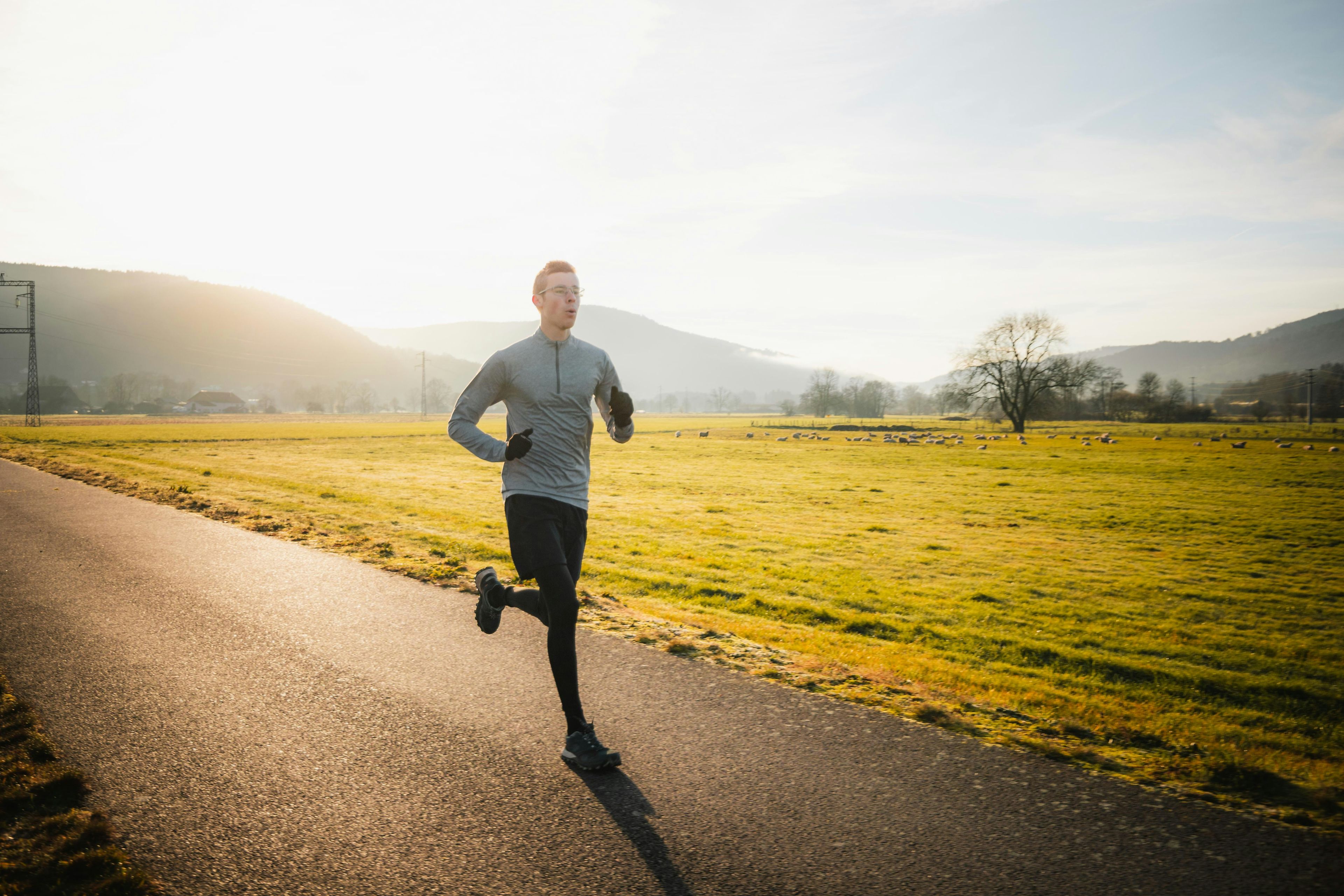 Privatist jogger langs en landevei i morgensol, illustrasjon for faget Helse og sykdom hos Sonans.