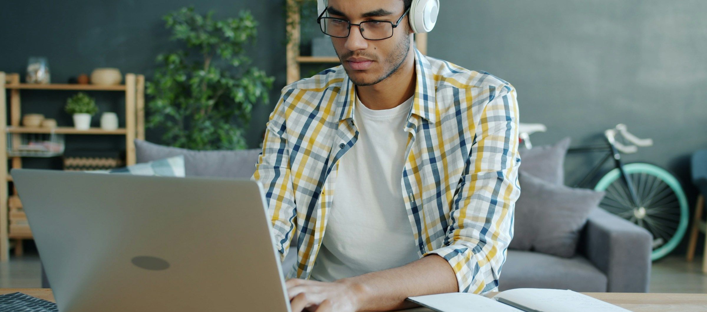 Mannlig student sitter foran en pc og studerer til eksamen.