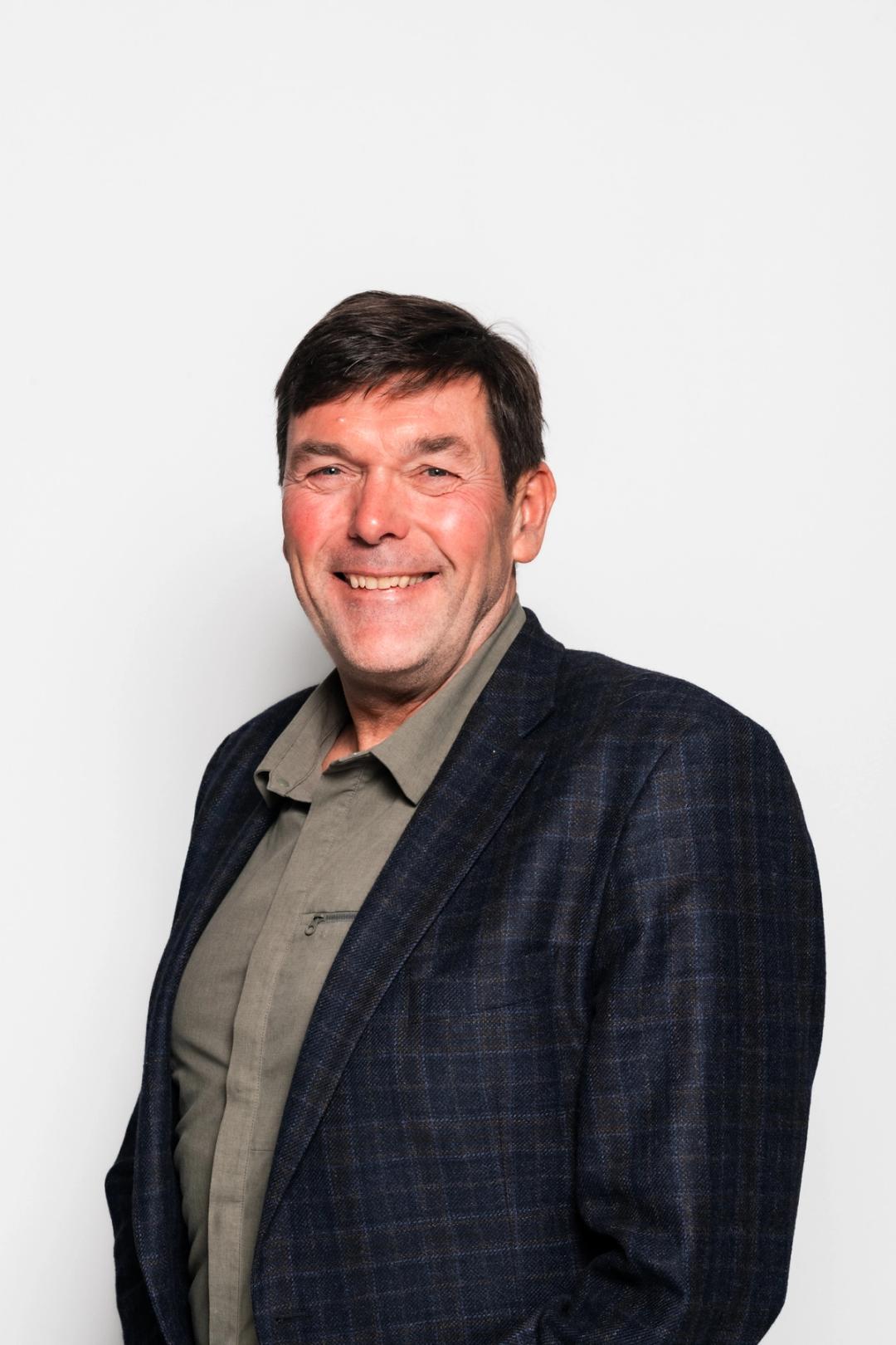 Regionsdirektør Arne Pukstad smiler med hvit bakgrunn