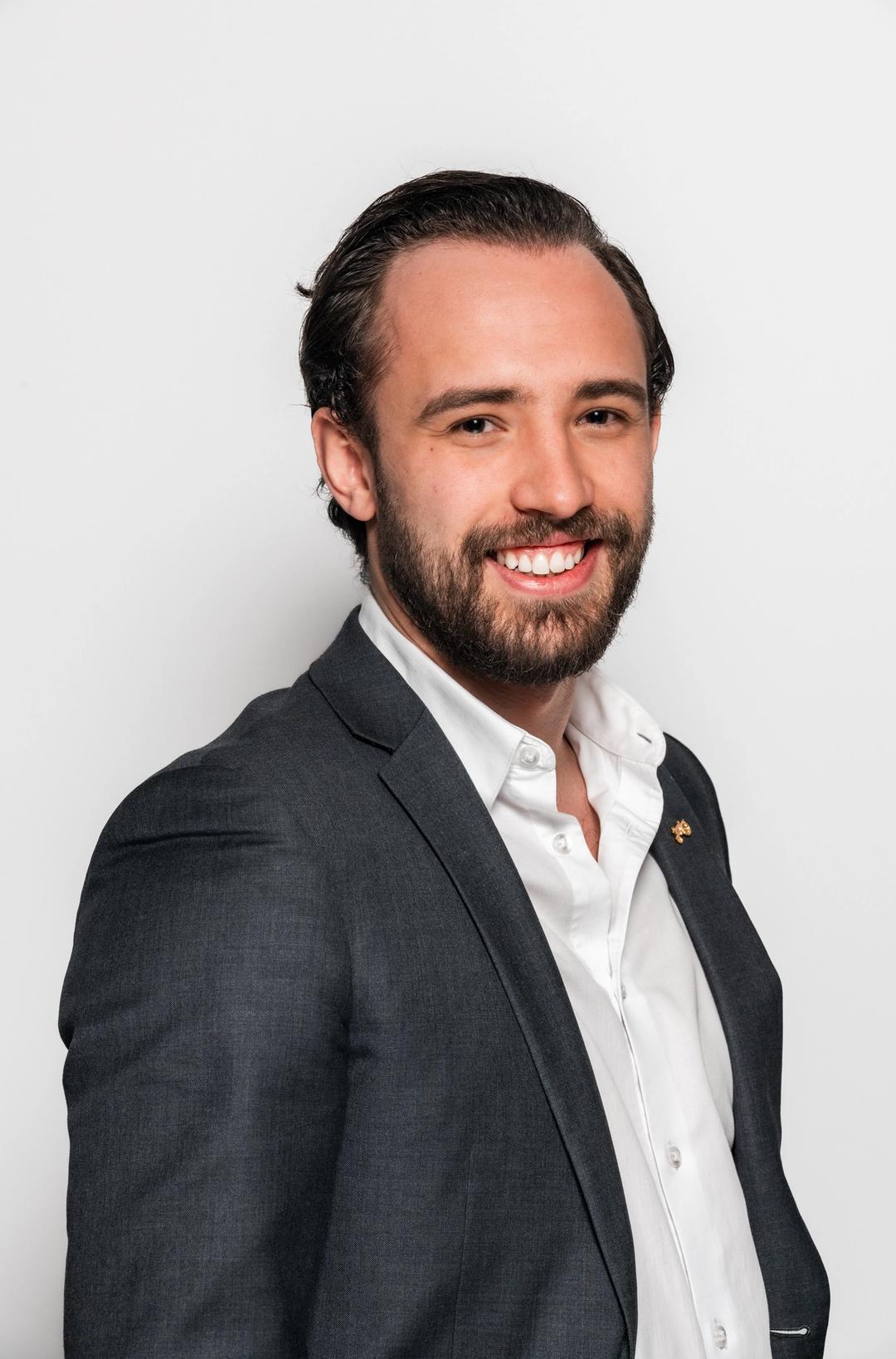 Avdelingsleder i Sonans Tønsberg, Emil Buarøy smiler med lys bakgrunn