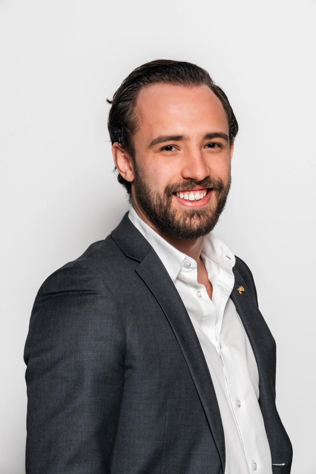 Avdelingsleder i Sonans Drammen, Emil Buarøy smiler med lys bakgrunn