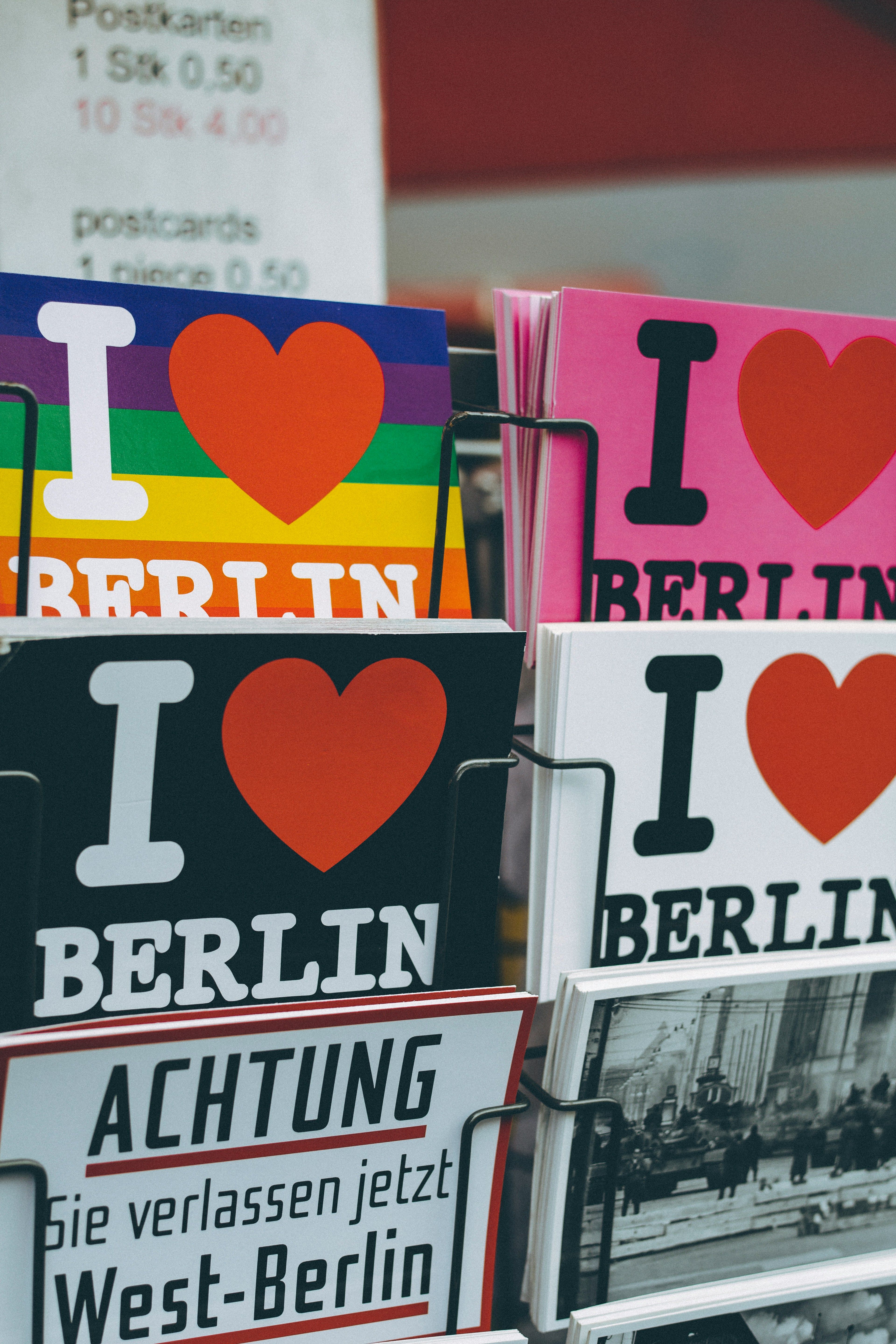 Postkortstativ med fargerike "I ❤️ Berlin"-kort og et skilt, språk og kultur er en viktig del av Tysk I programfag.