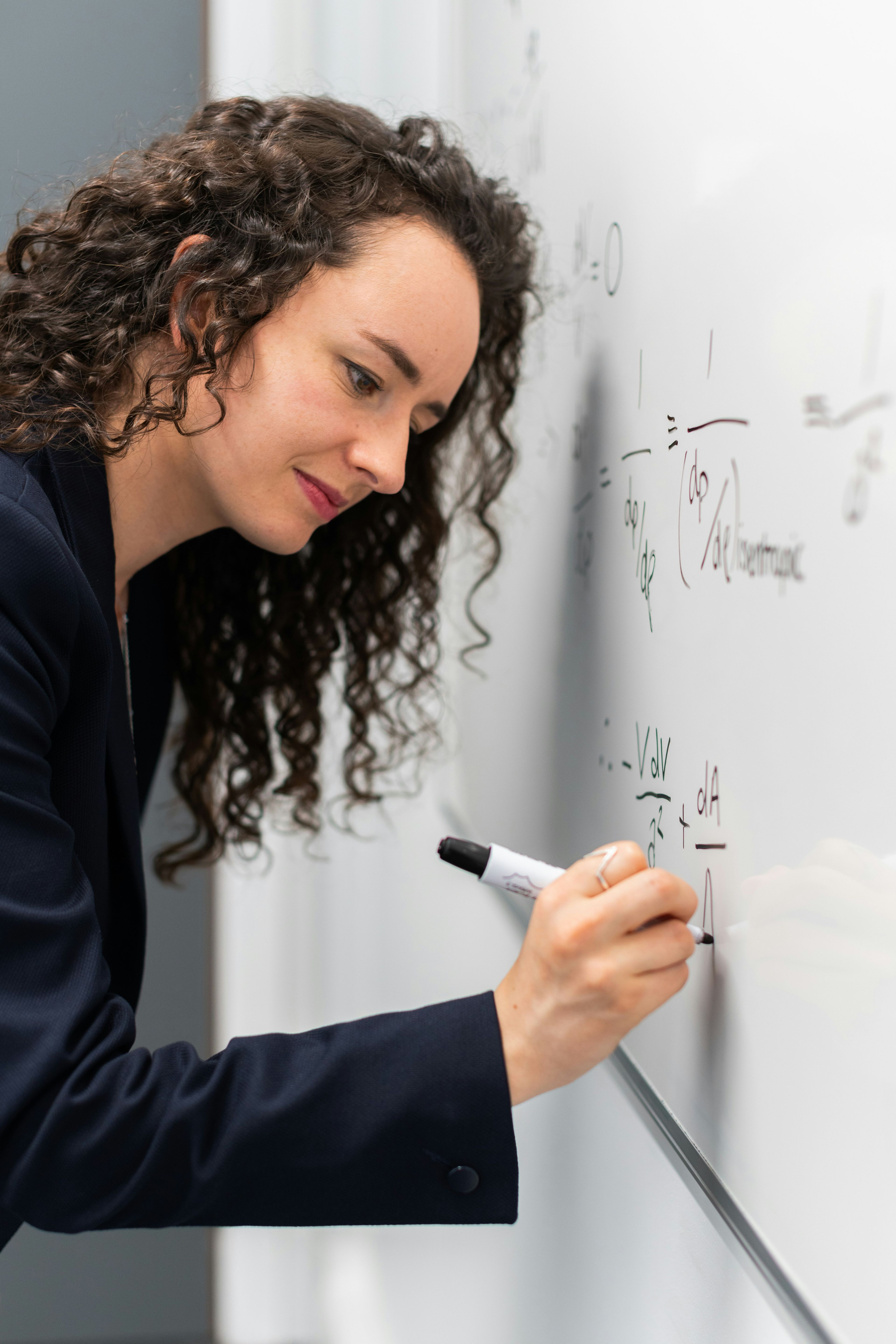 Lærer skriver matematiske formler på tavle i undervisning i Matematikk R2.