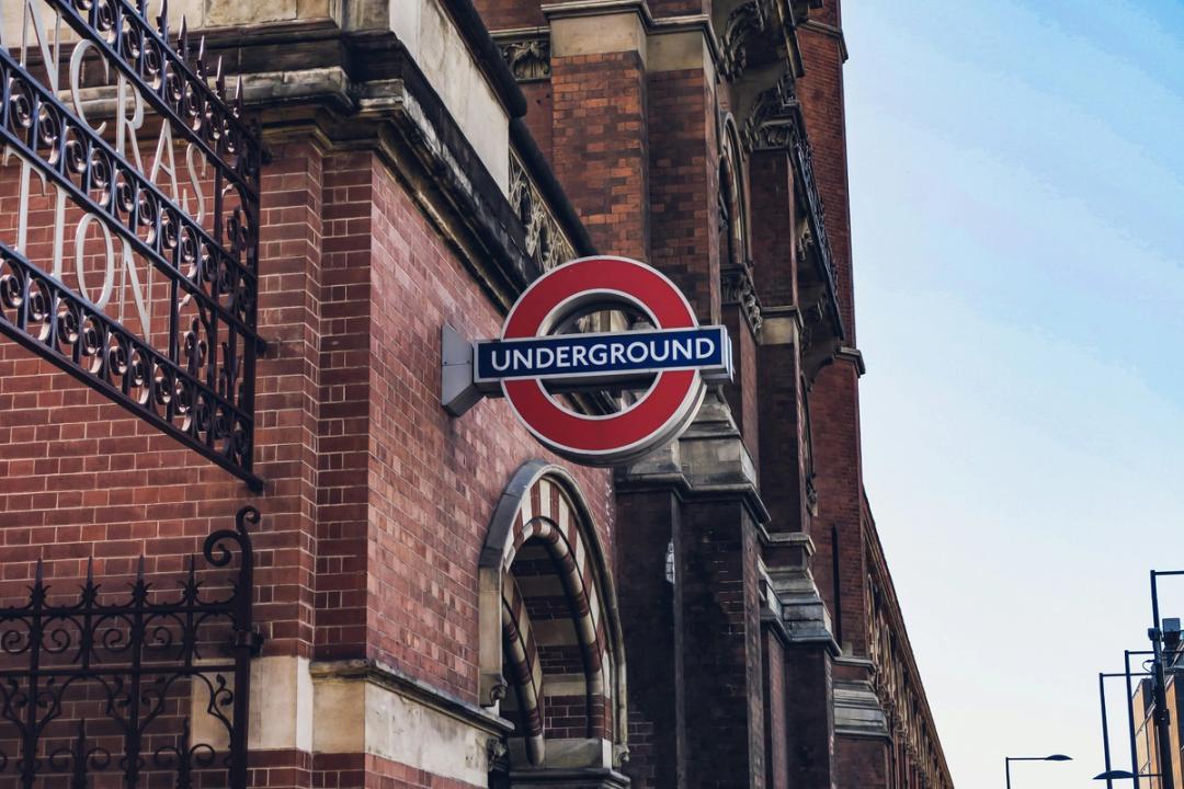 London Underground-skilt på en murbygning, symboliserer engelsk språk og kultur.