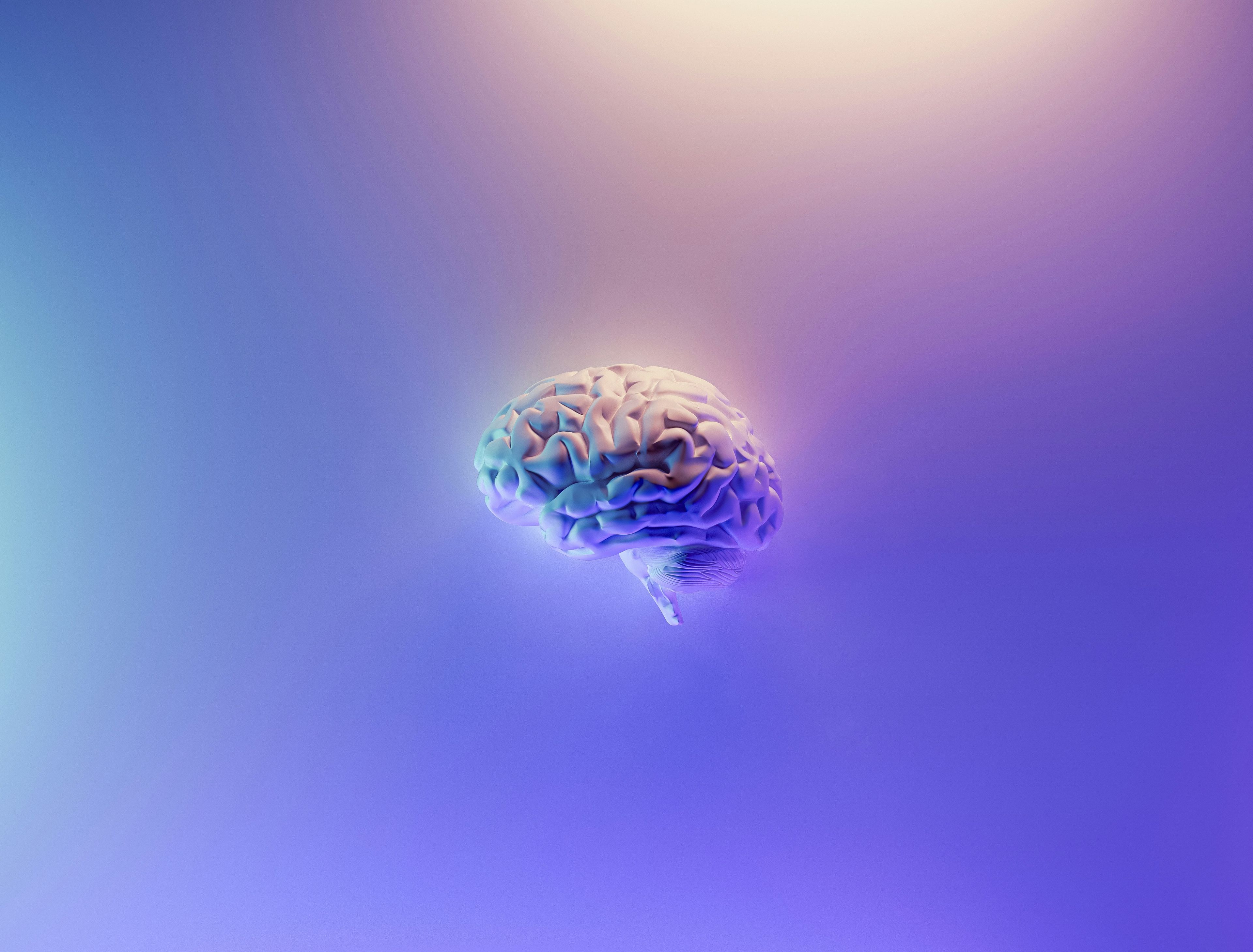 Illustrasjon av en menneskehjerne med futuristisk farget lys - representerer psykologi og tankeprosessene i Psykologi 2 ved Sonans.