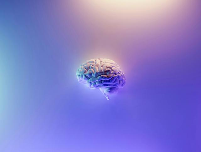 Illustrasjon av en menneskehjerne med futuristisk farget lys - representerer psykologi og tankeprosessene i Psykologi 2 ved Sonans.