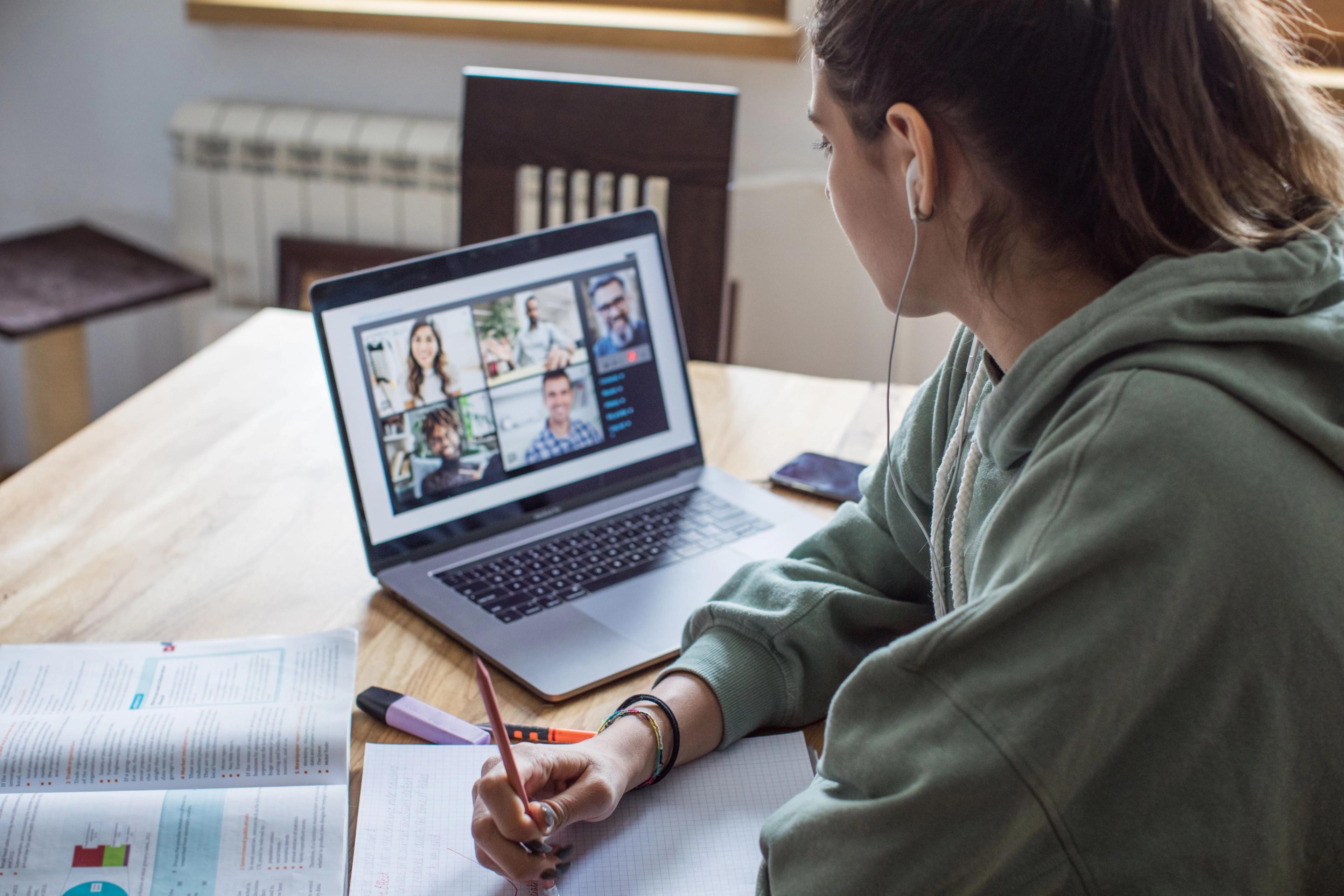 Kvinnelig Sonans yrkesfag student følger undervisning i digitalt klasserom på pc.