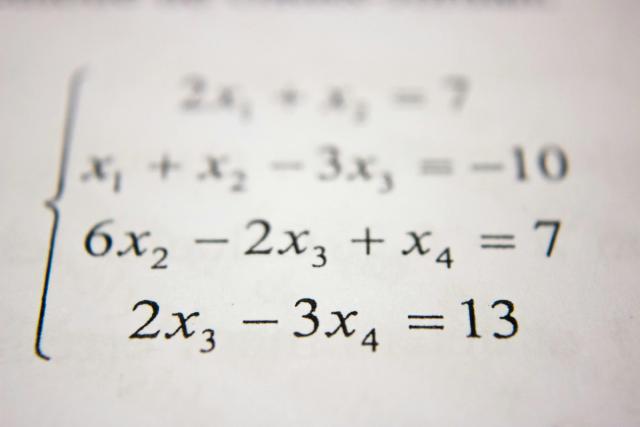 Matematiske likninger skrevet på papir, med fokus på algebra og variabler - typisk innhold i faget Matematikk S2.
