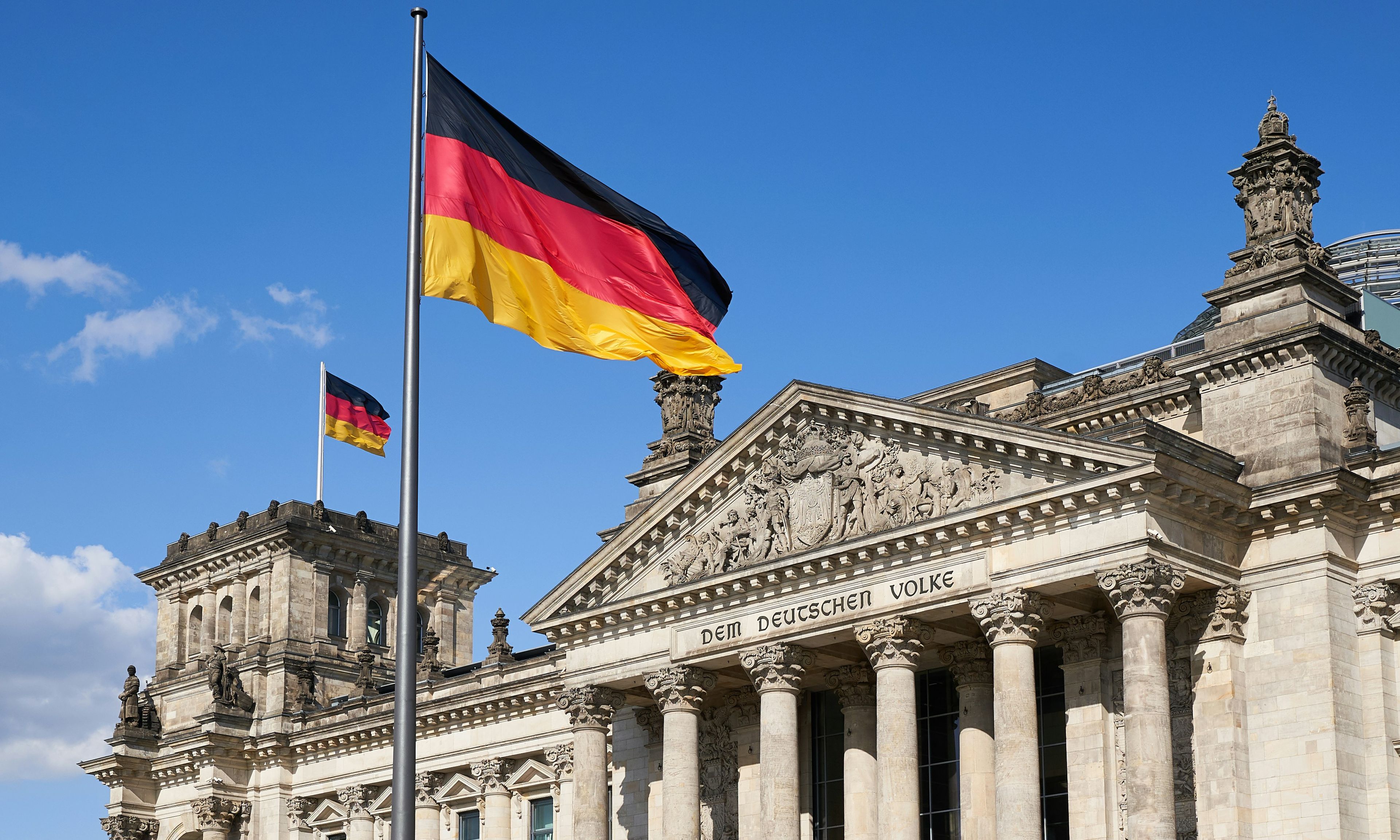 Tysk Bundestag med det tyske flagget vaiende - illustrerer samfunnsforståelse og interkulturell kompetanse i Tysk II programfag.