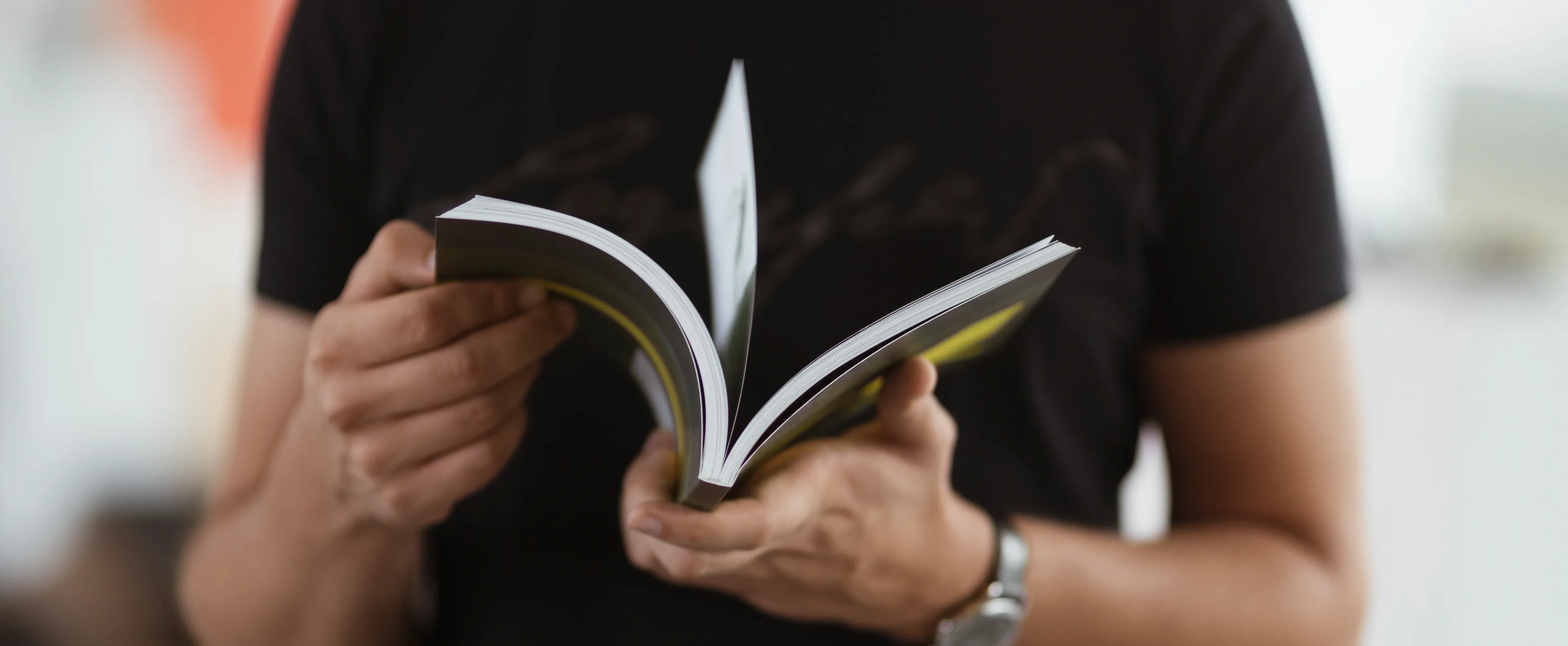 Sonans student blar i en bok, iført en mørk t-skjorte.